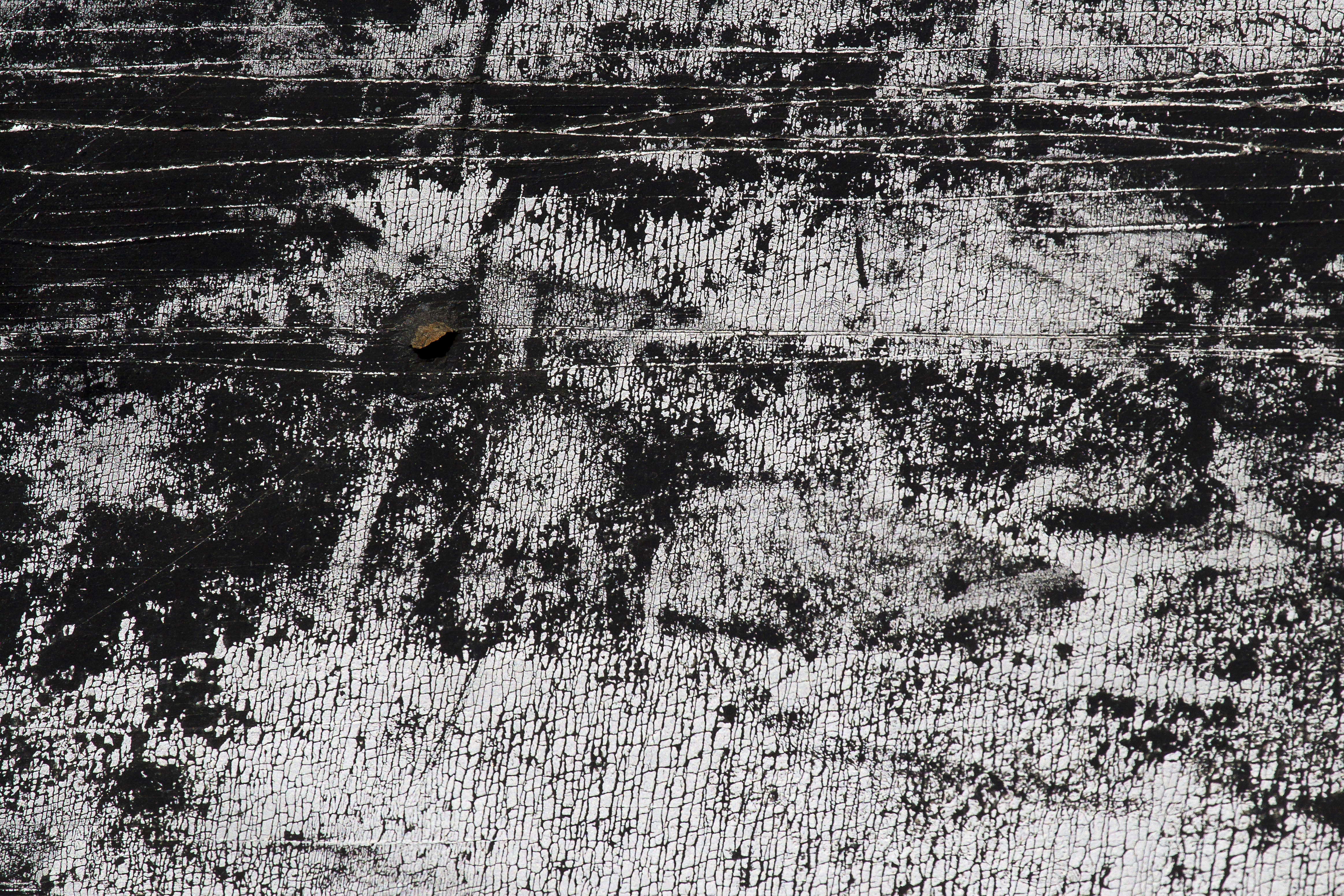 Orange rust blooms out, dark scales crust on pitted steel, grit meets the shadow