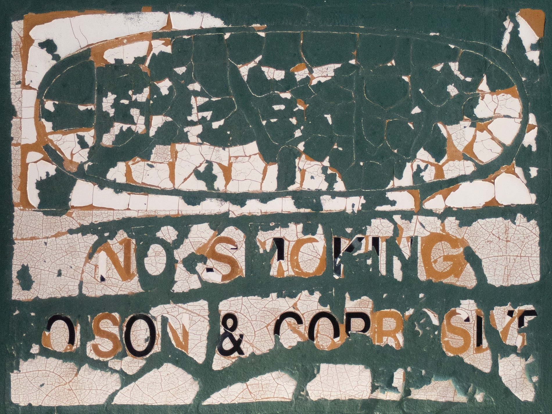 Green sign flakes away, white paint cracks like desert mud, warnings fade from sight