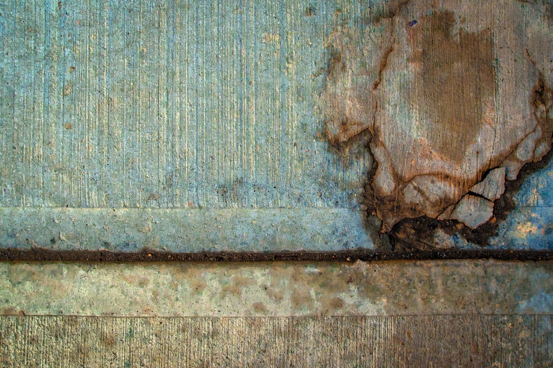 Blue fields turn to grey, orange veins cut through the stone, grit holds the pattern