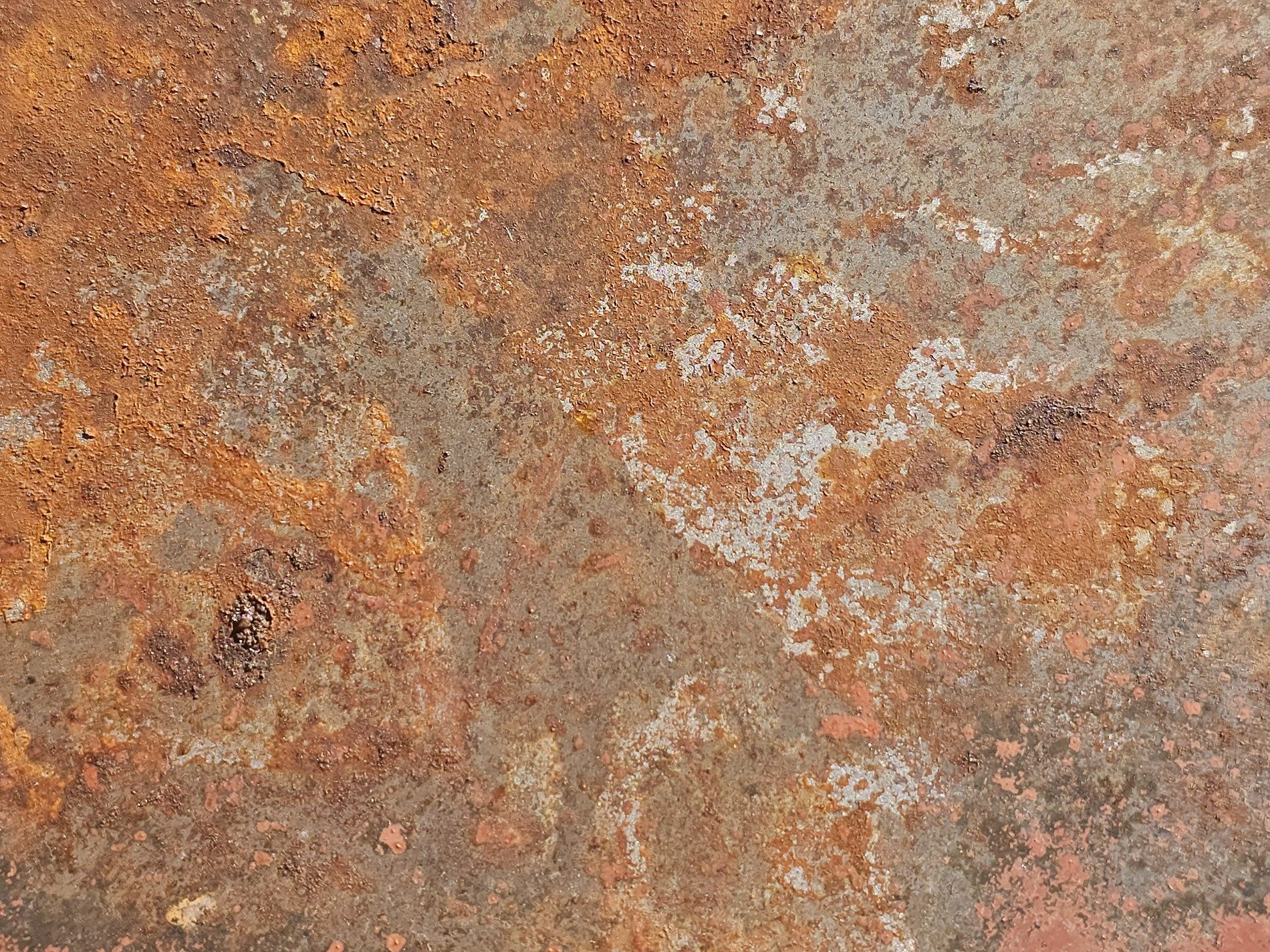 Blue paint holds the edge, orange spots mark the surface, grit marks the finish
