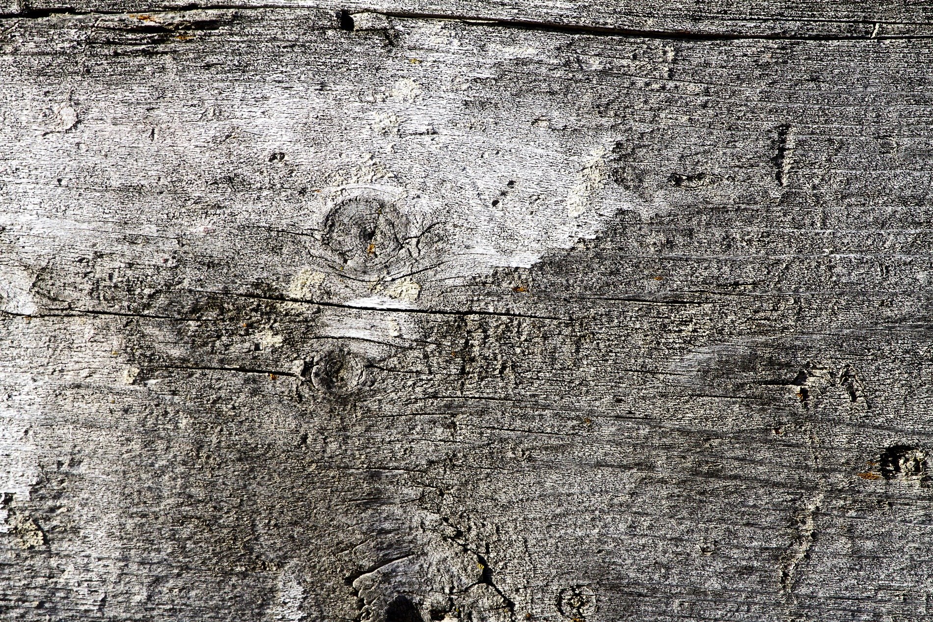 Blue paint peels away, brown rust eats the heavy steel, flakes drift on the grit