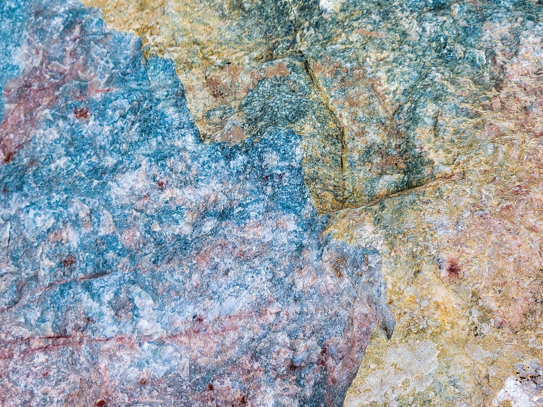 Bright veins cut the field, jagged colors meet the edge, light catches the shards