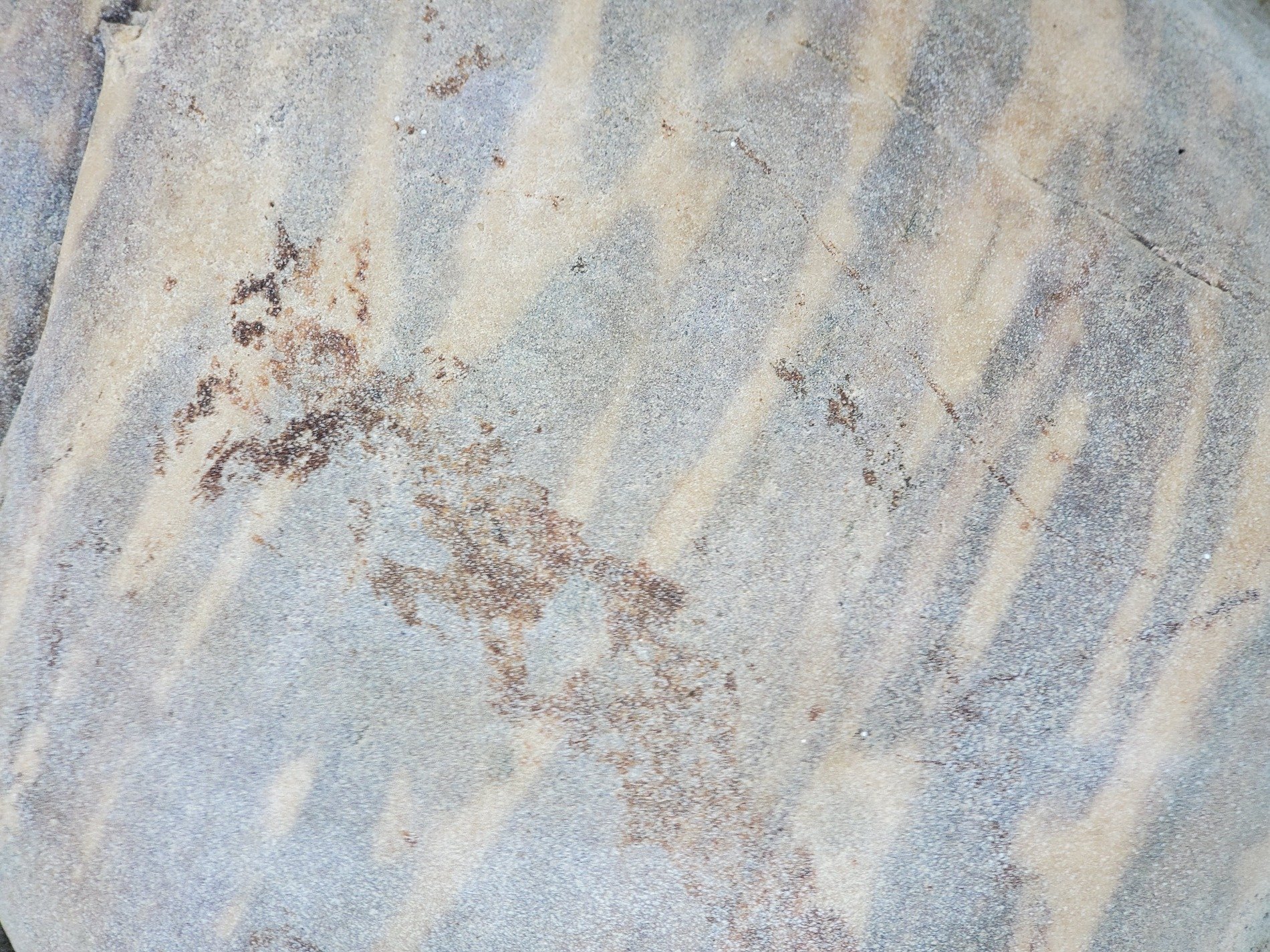 Tan bands drift slowly, mineral lines trace the path, aged stone holds its form