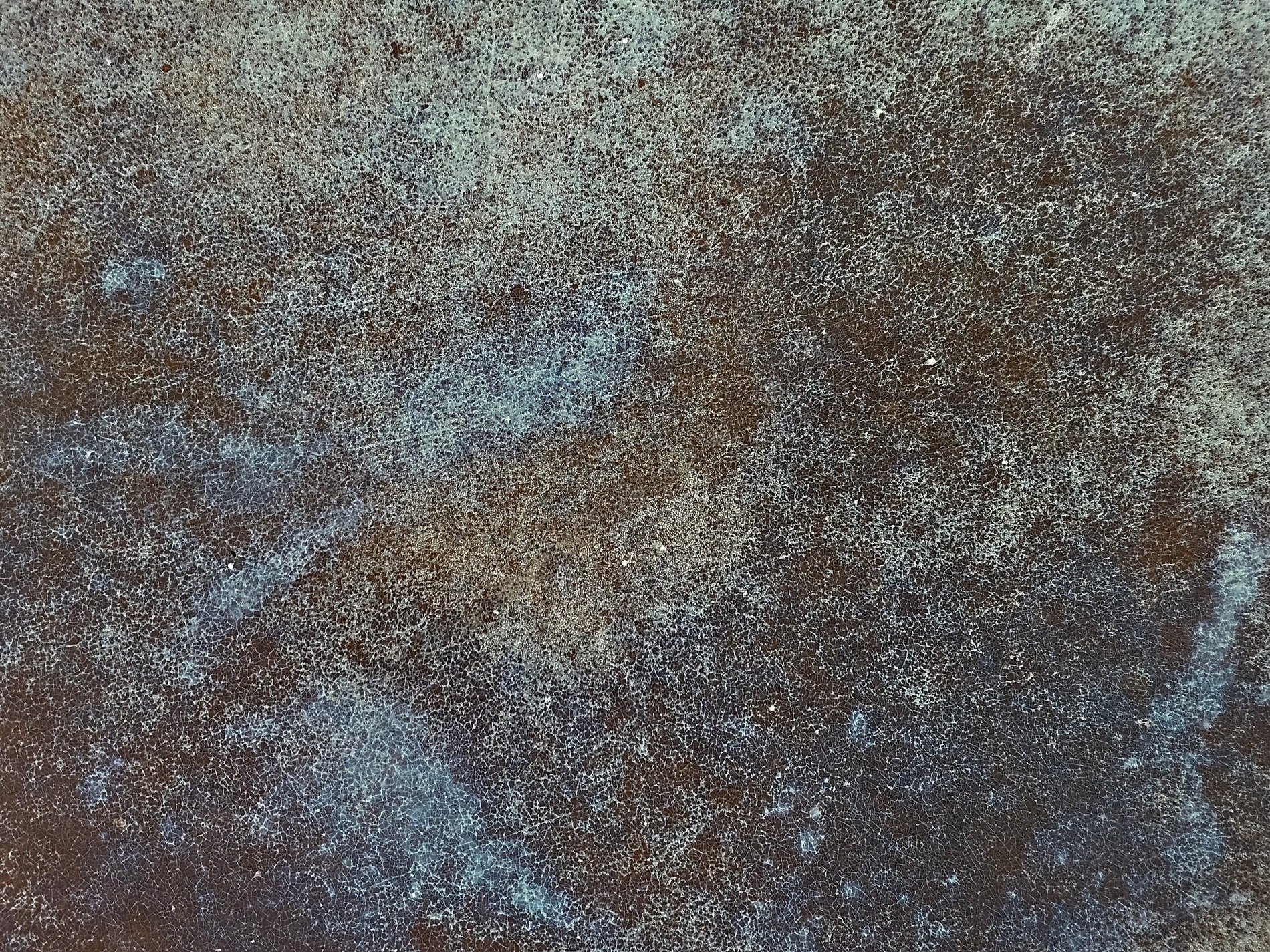 Dark veins weave through deep, jagged cracks trace the surface, light marks the finish