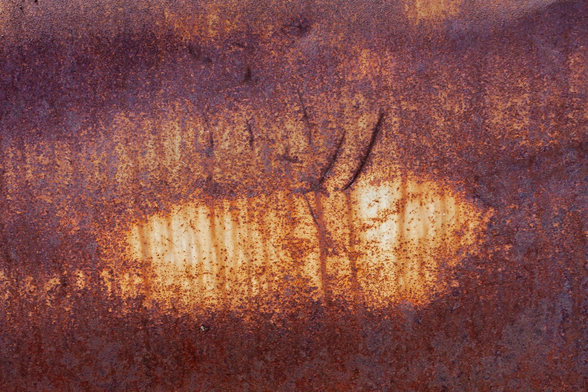 Deep rust holds the edge, orange bleeds across the steel, scratches mark the face