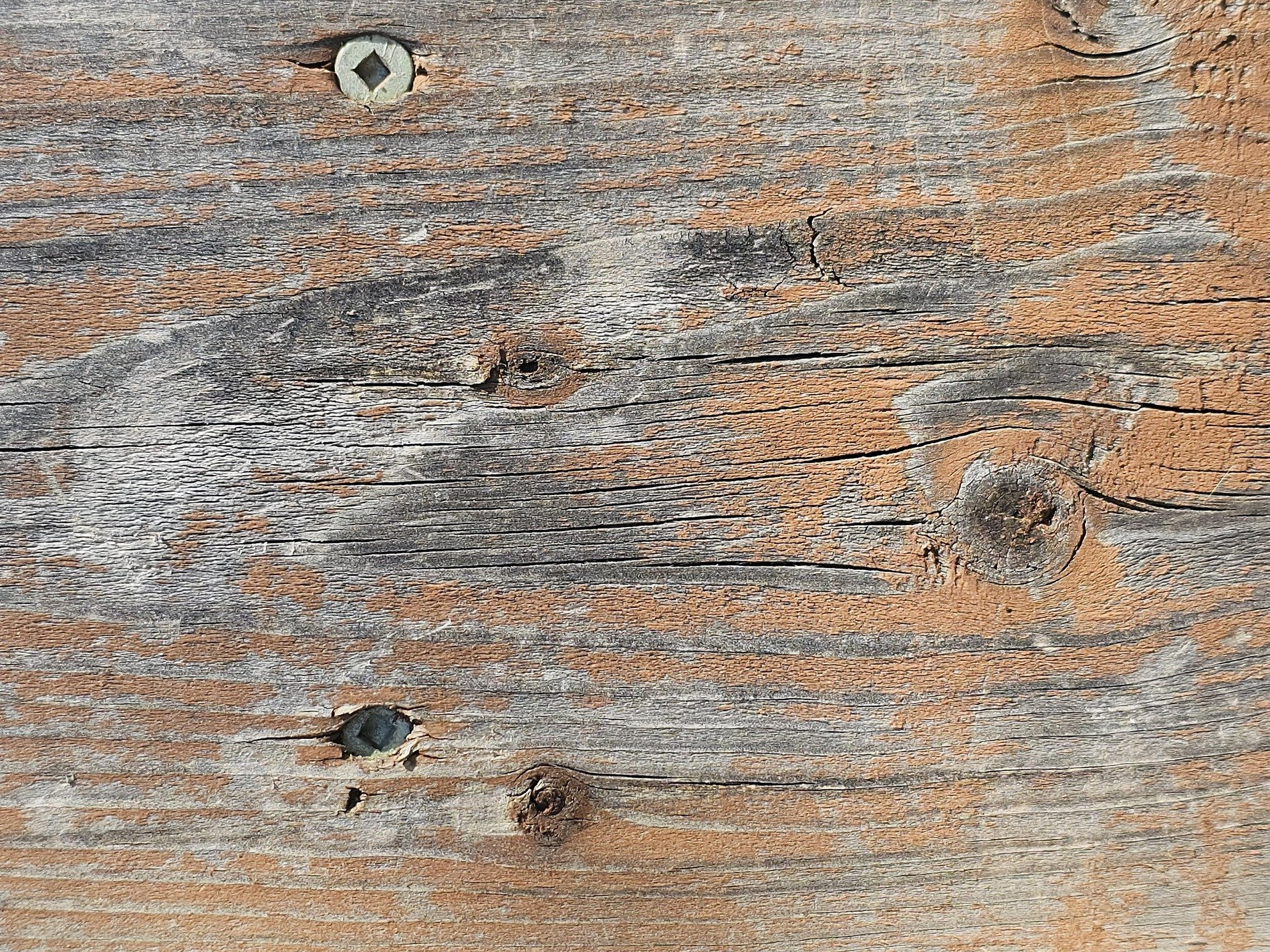 Fading stain on wood, brown grain flows through the board, time holds the finish