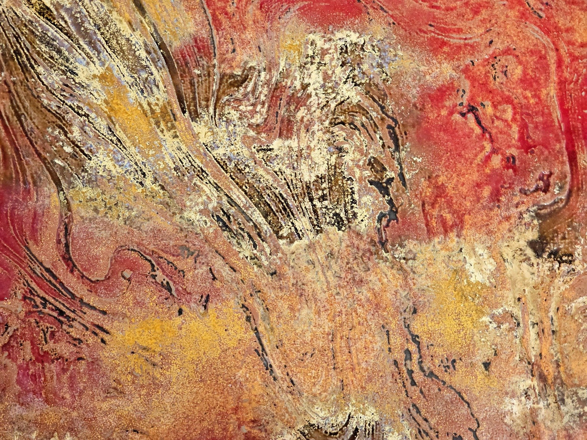 Grey grains flow through deep, orange spots mark the surface, grit holds the pattern