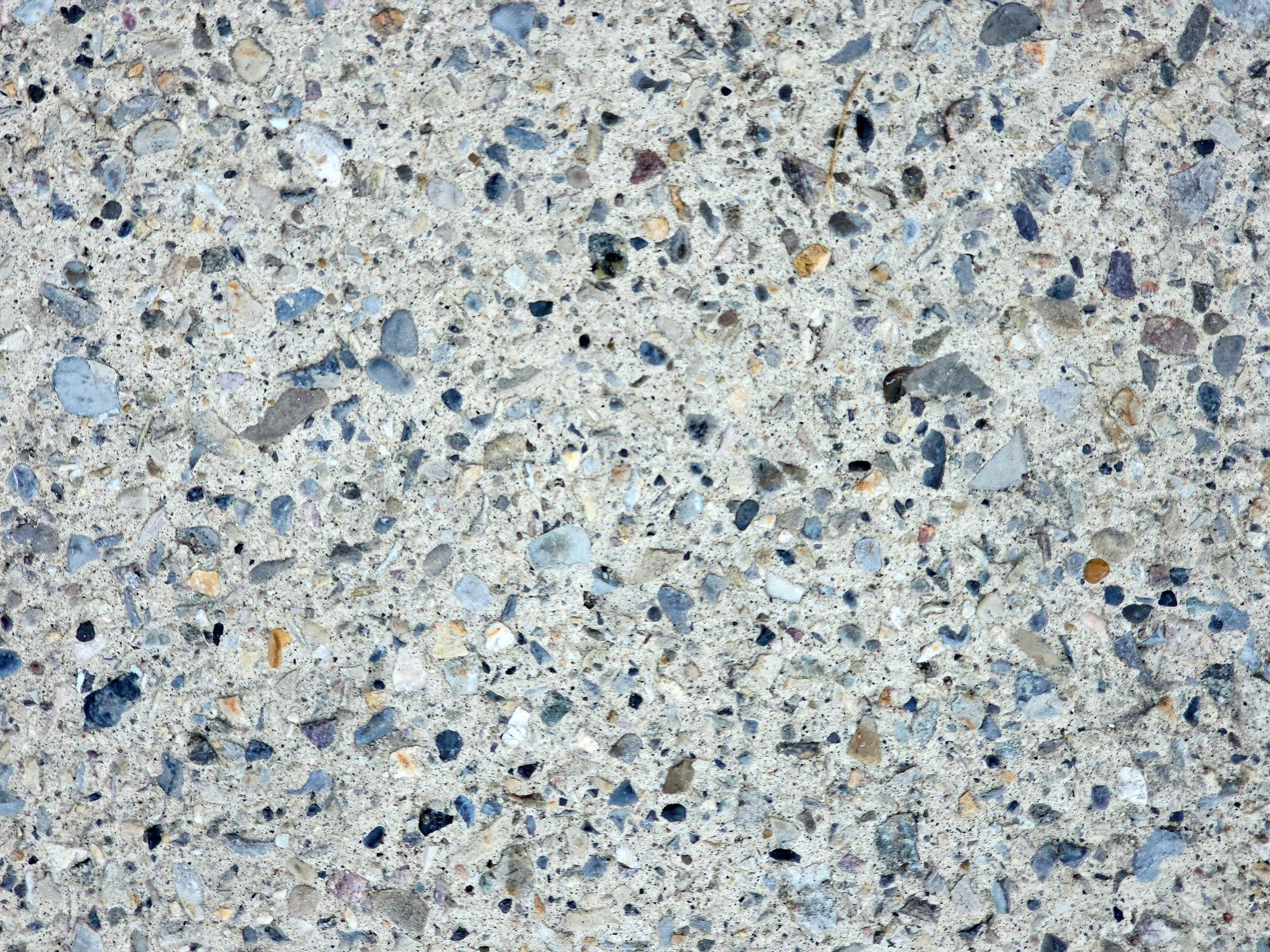 Smooth stones locked in place, grey sand binds the scattered gems, rough path worn by time