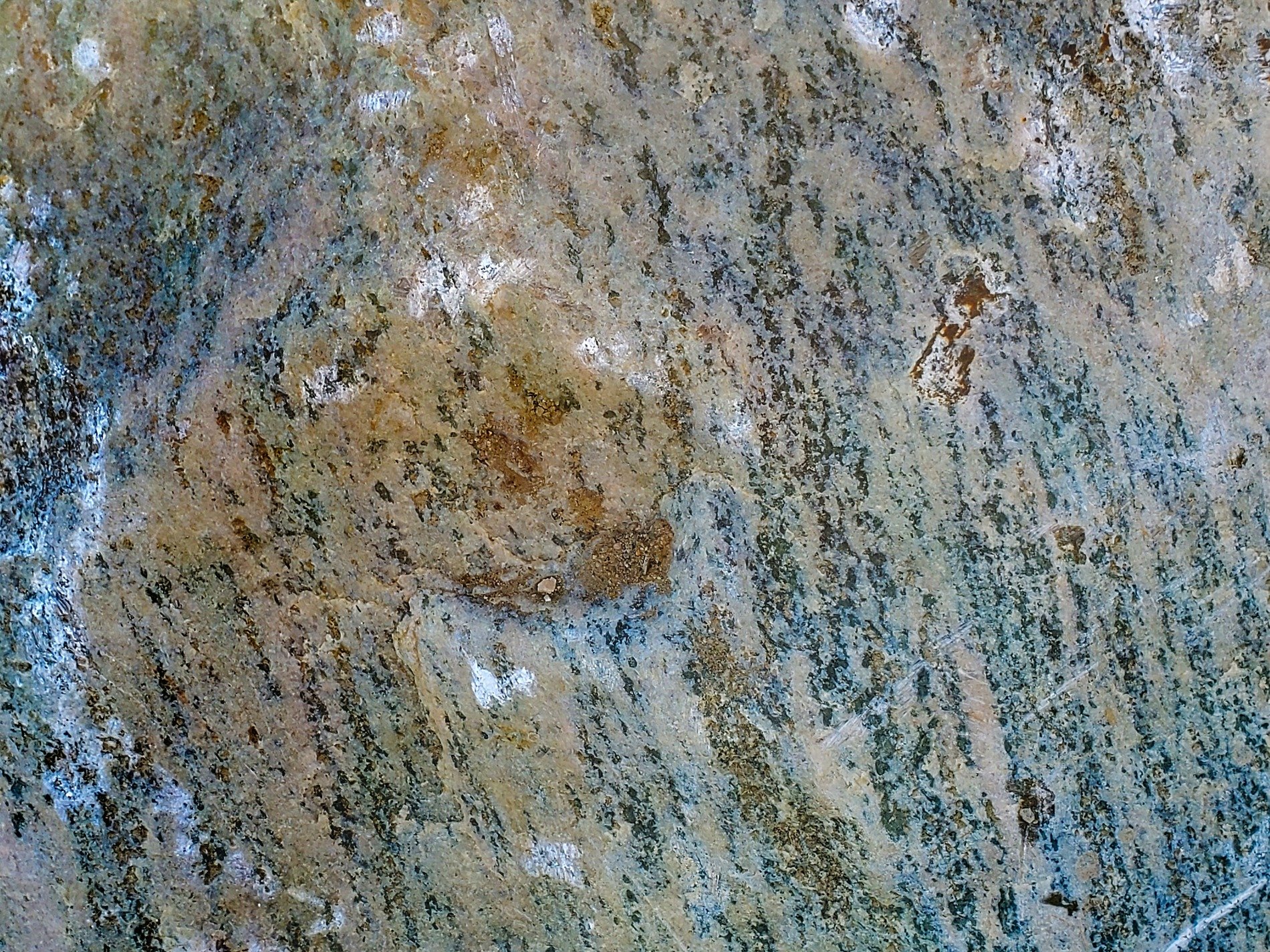Grey stone holds the light, speckled grains of blue and brown, ancient earth remains