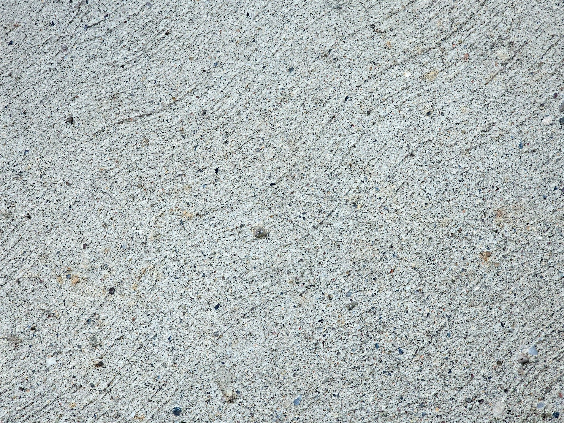 Grey stone spreads across, rough lines trace a path unseen, grit holds steady fast