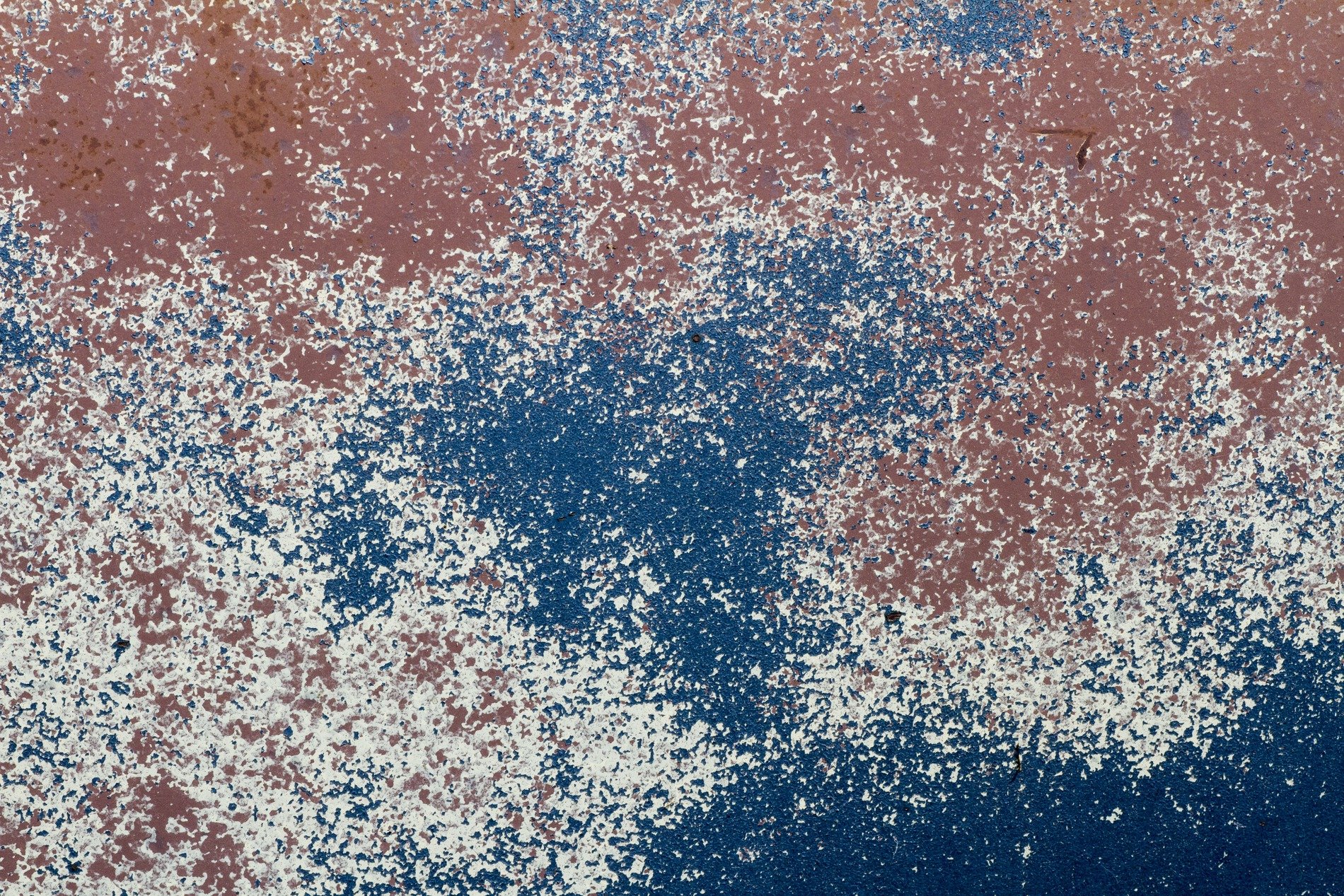 Heavy rust scales on blue steel, orange minerals claim the car body, time leaves a thick mark