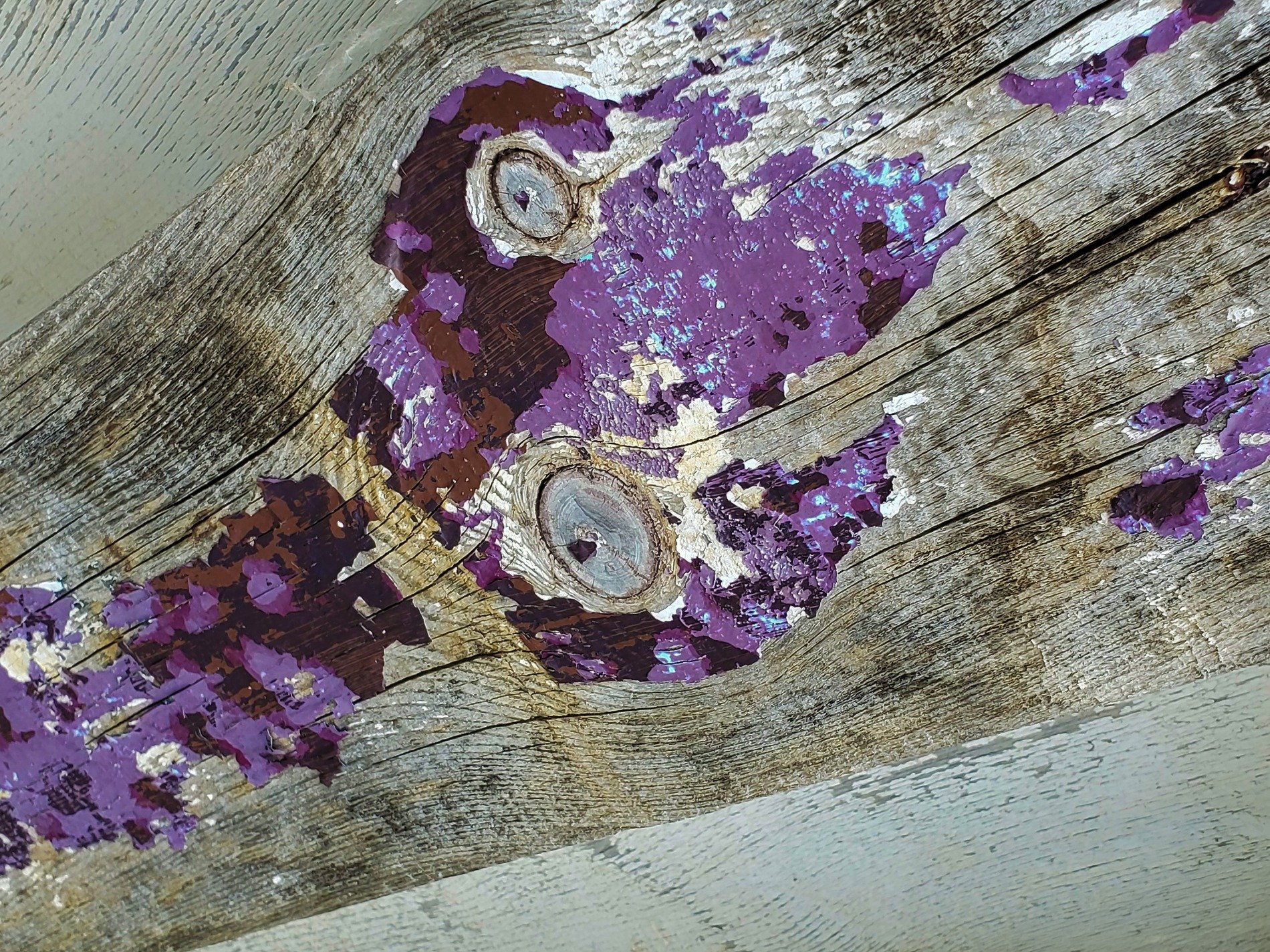 Light blue flakes drift off, jagged edges meet the light, grit marks the finish