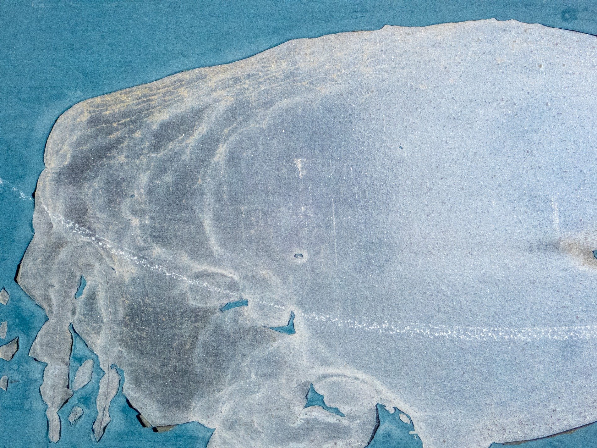 Lines cut through the grit, jagged marks trace the surface, time carves out the mark