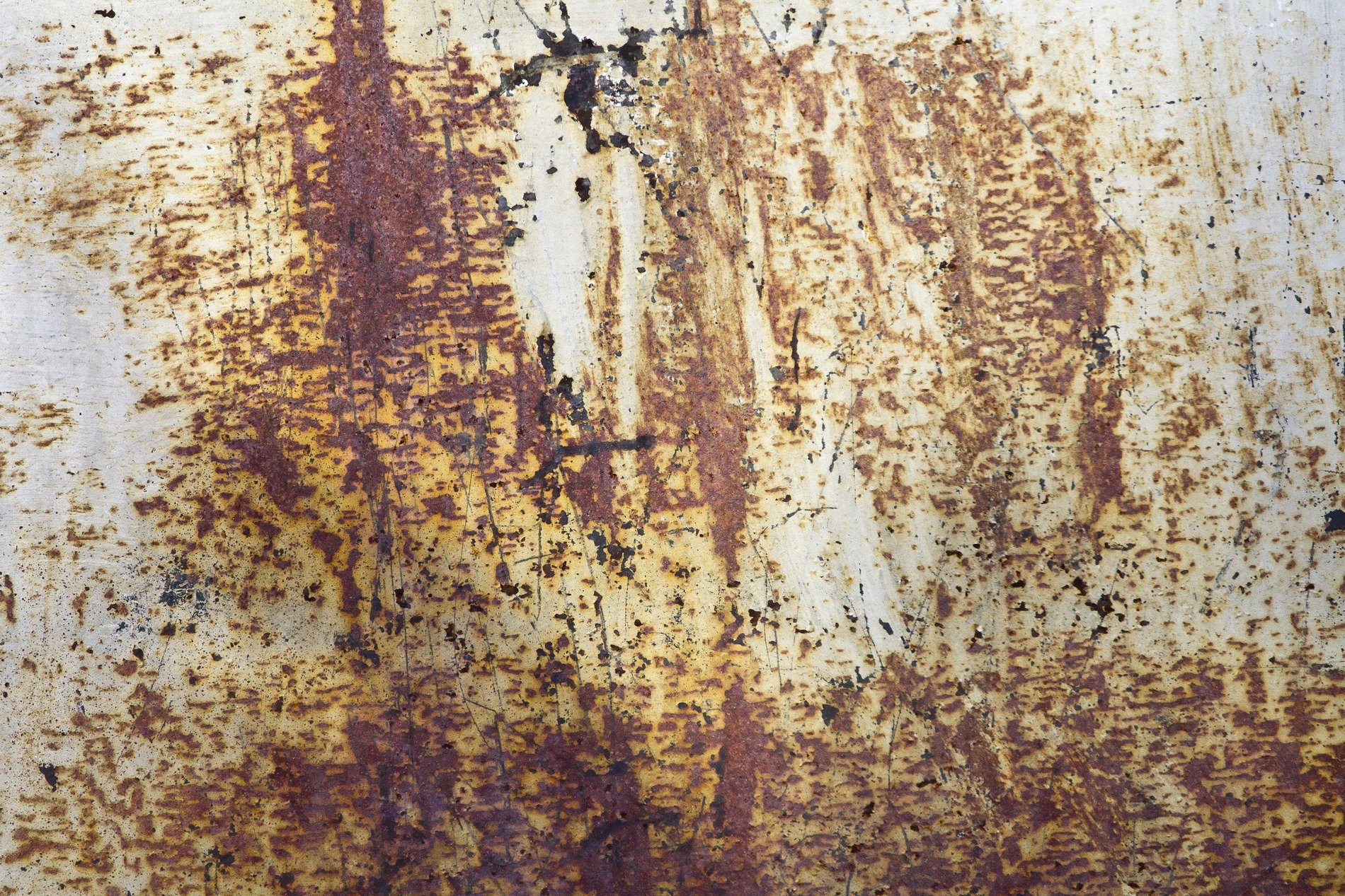 Orange dust on steel, rough pits scar the heavy plate, rust claims the finish