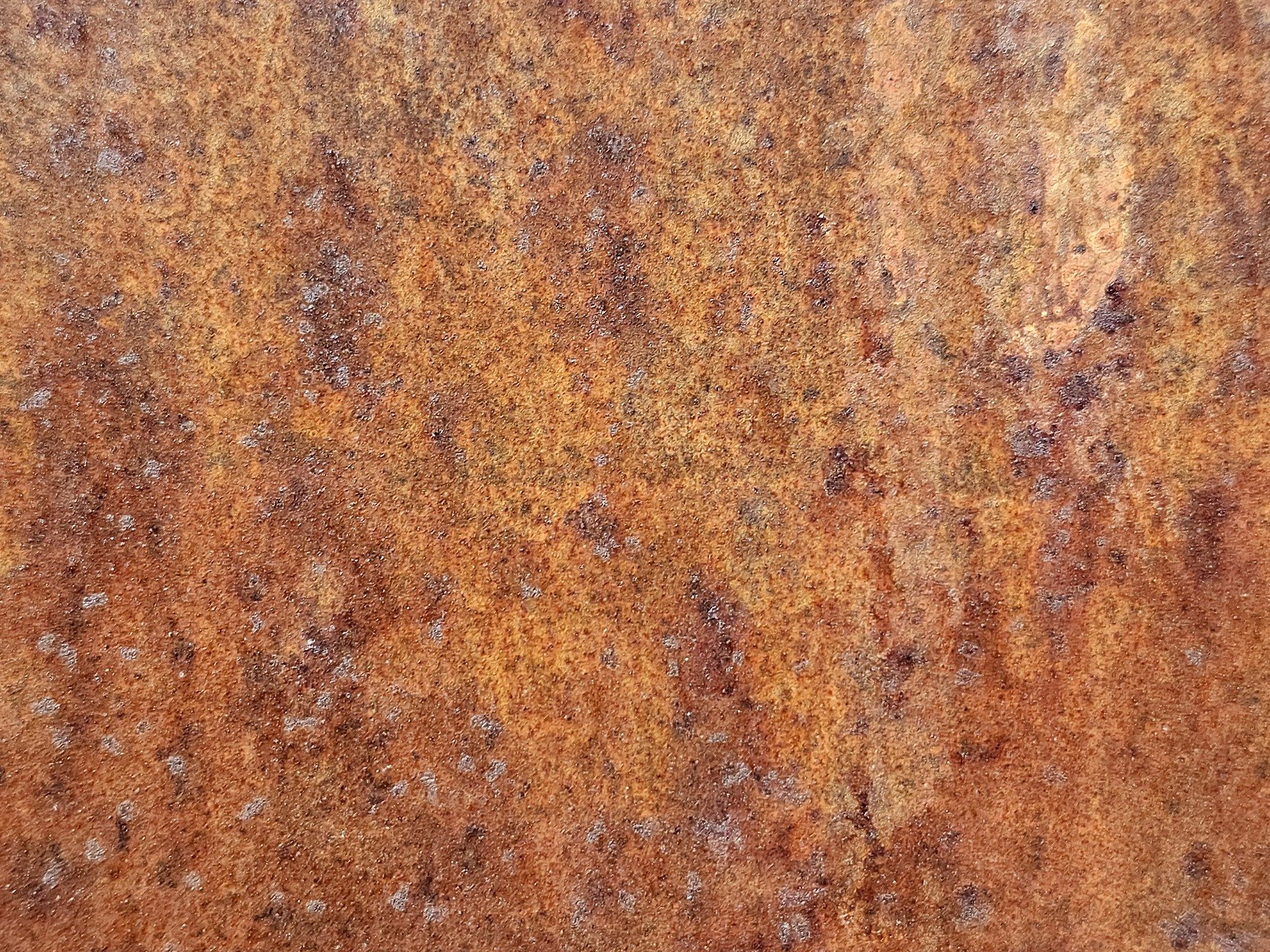 Orange dust on the steel, rough pits scar the heavy plate, rust claims the surface