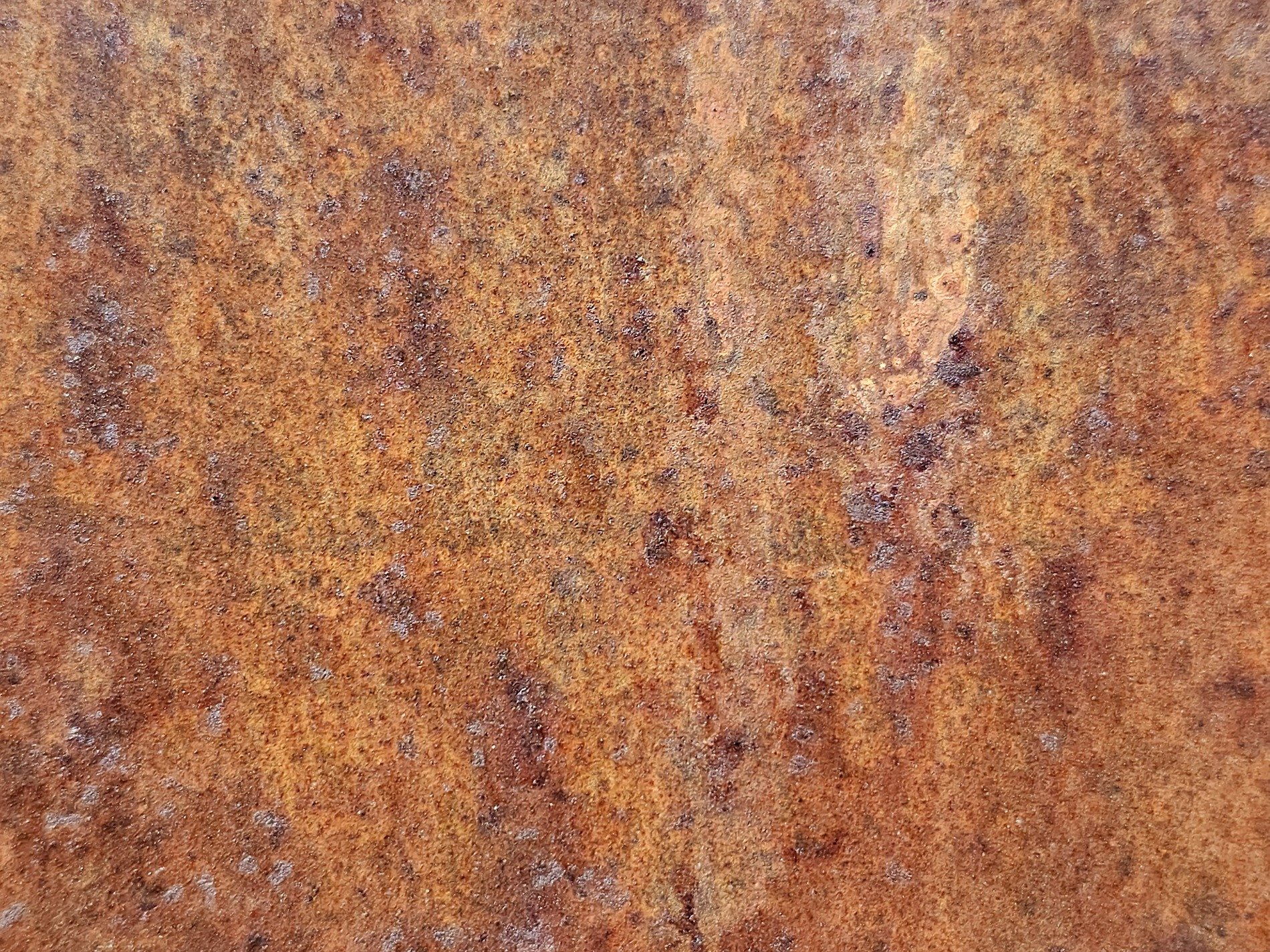 Orange dust on the stone, rough pits scar the heavy rock, mineral flows deep