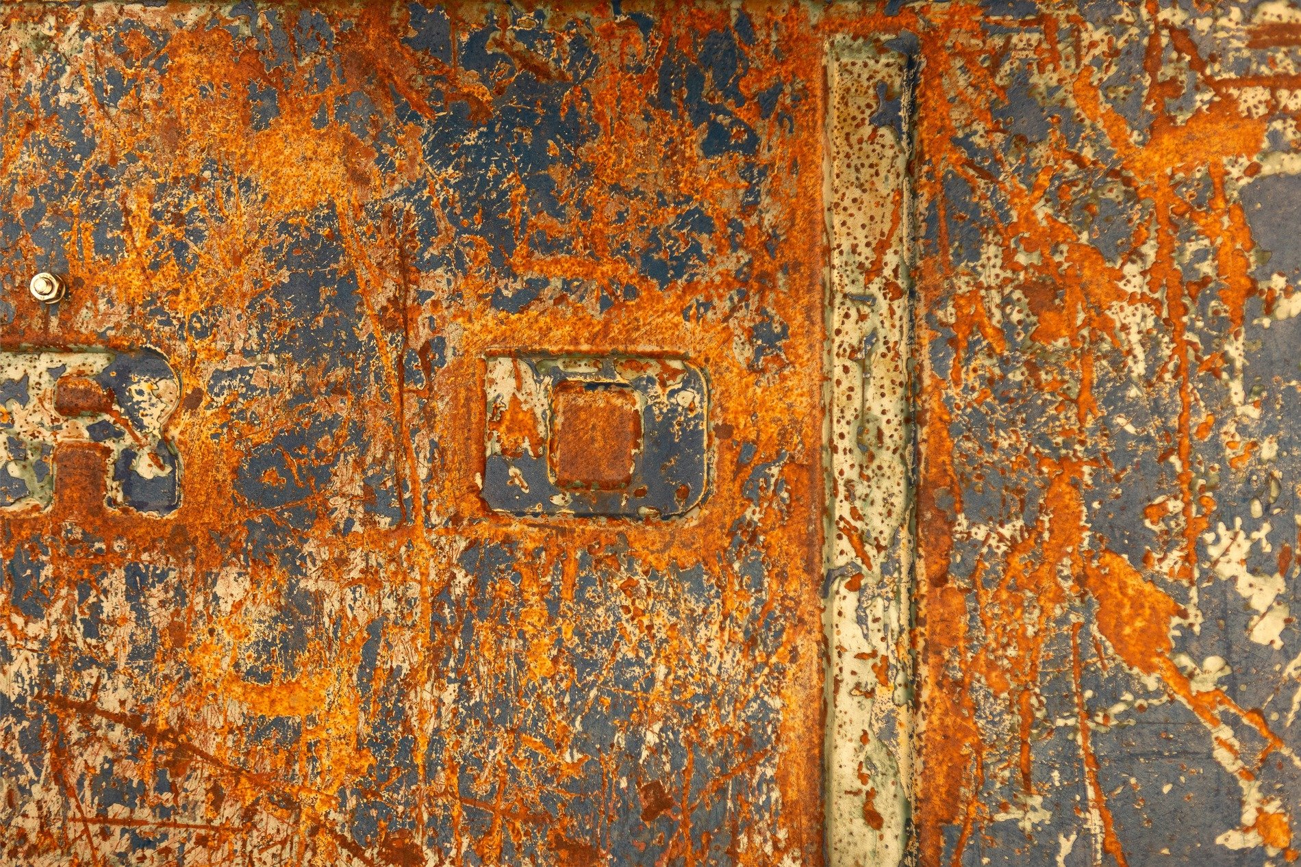 Orange rust blooms bright, heavy scars on fading blue, letters slowly fade