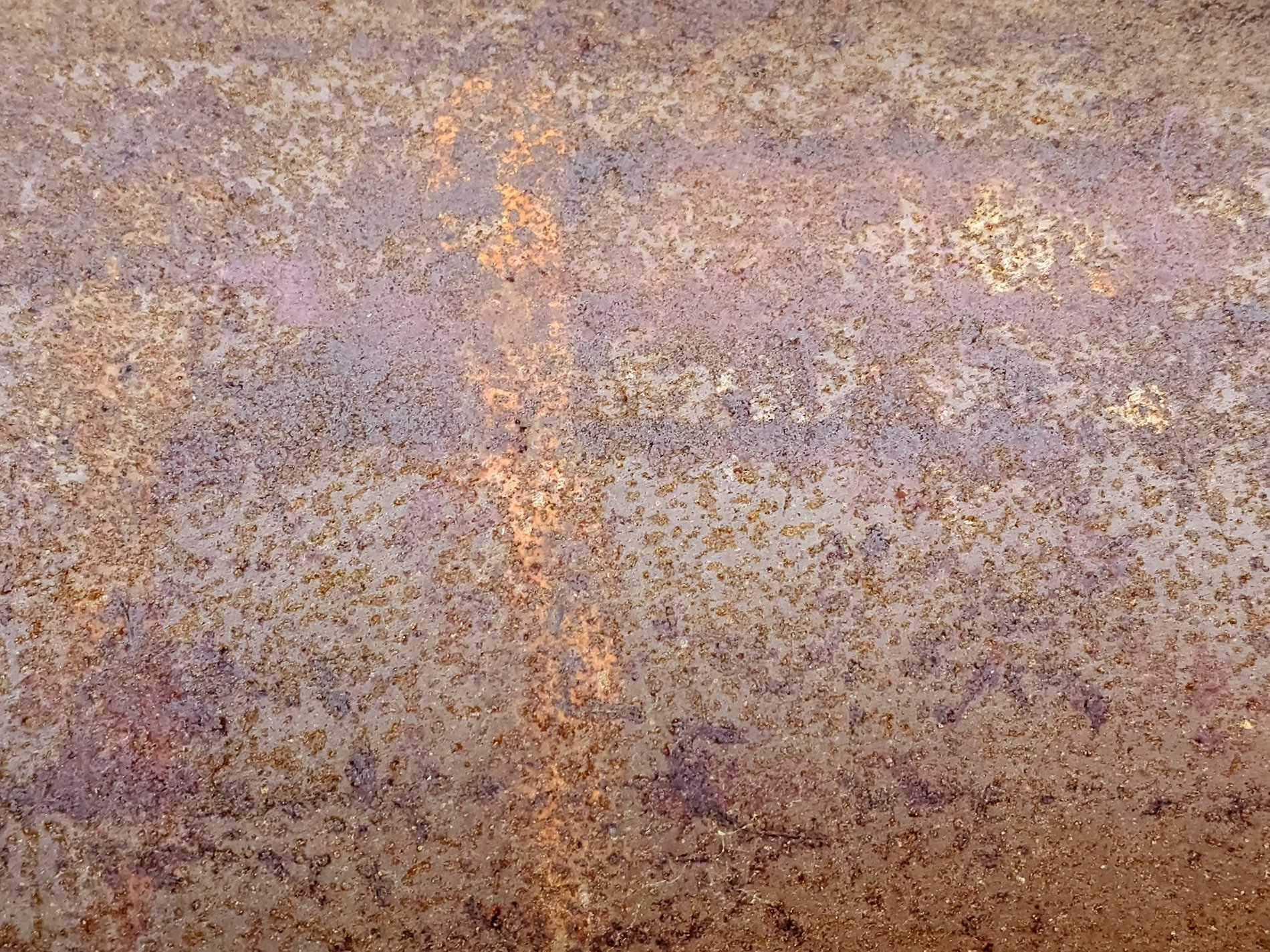 Orange rust takes all, brown minerals bloom on the steel, time claims the plate