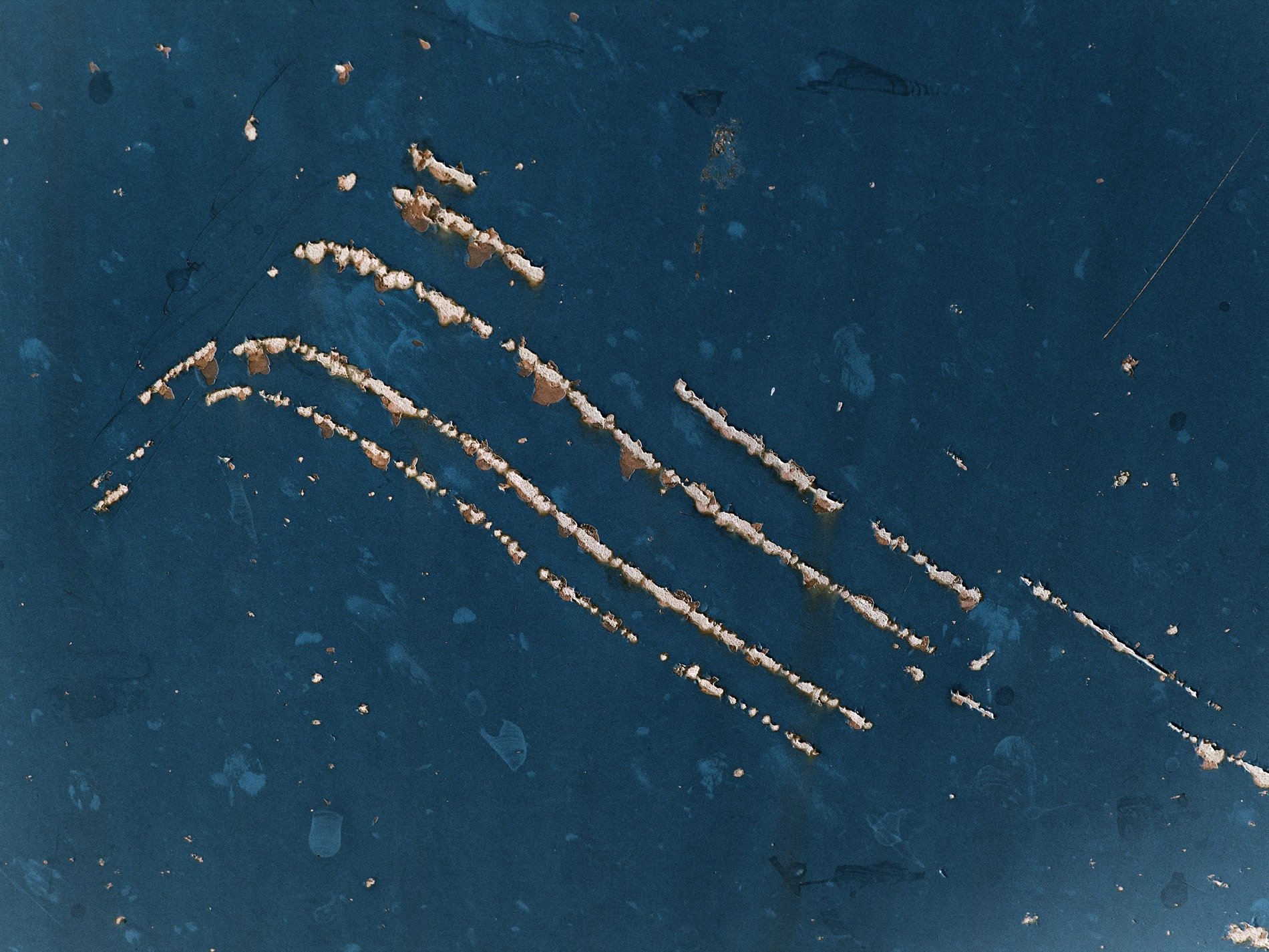 Orange rust takes all, red paint fades to heavy brown, steel turns into grit