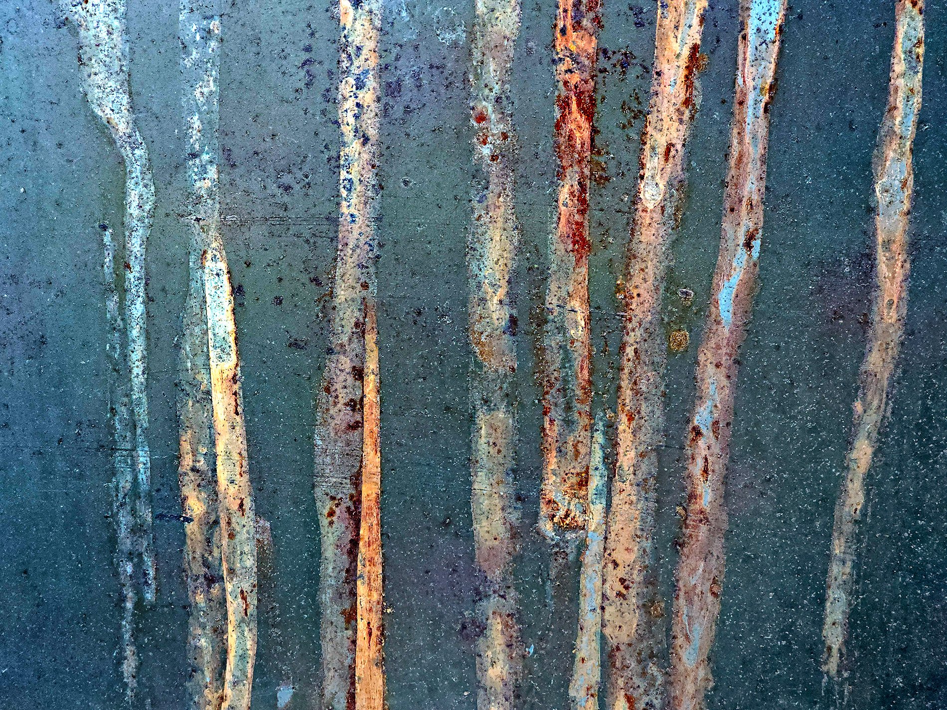 Orange streaks of rust, bleeding down the dark grey steel, time flows in colors