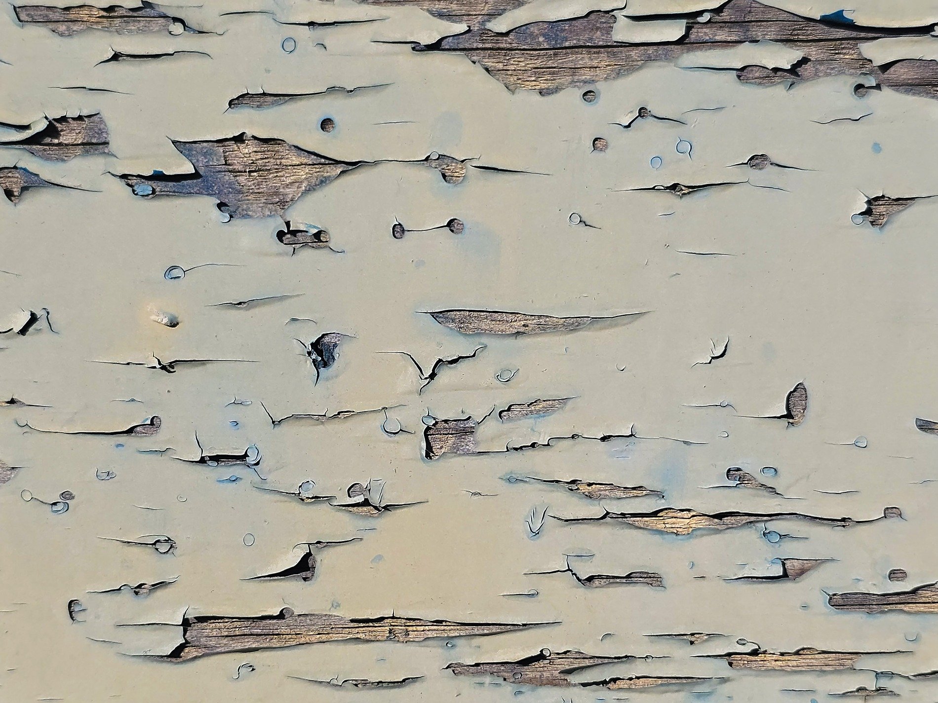 Pale blue paint peels back, dry wood waits beneath the cracks, grit holds the old lines