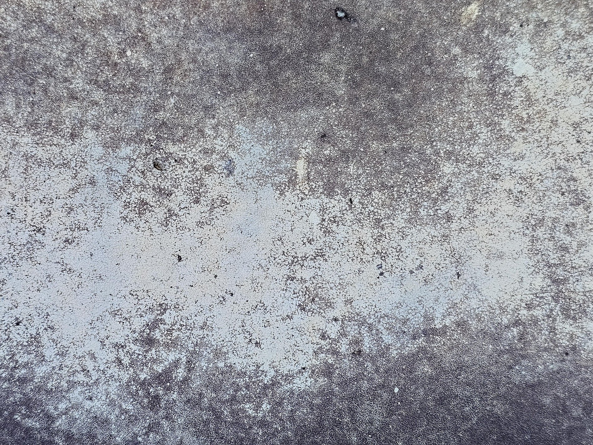 Pale grit marks the wall, dark webs hold the fading light, grit meets the finish