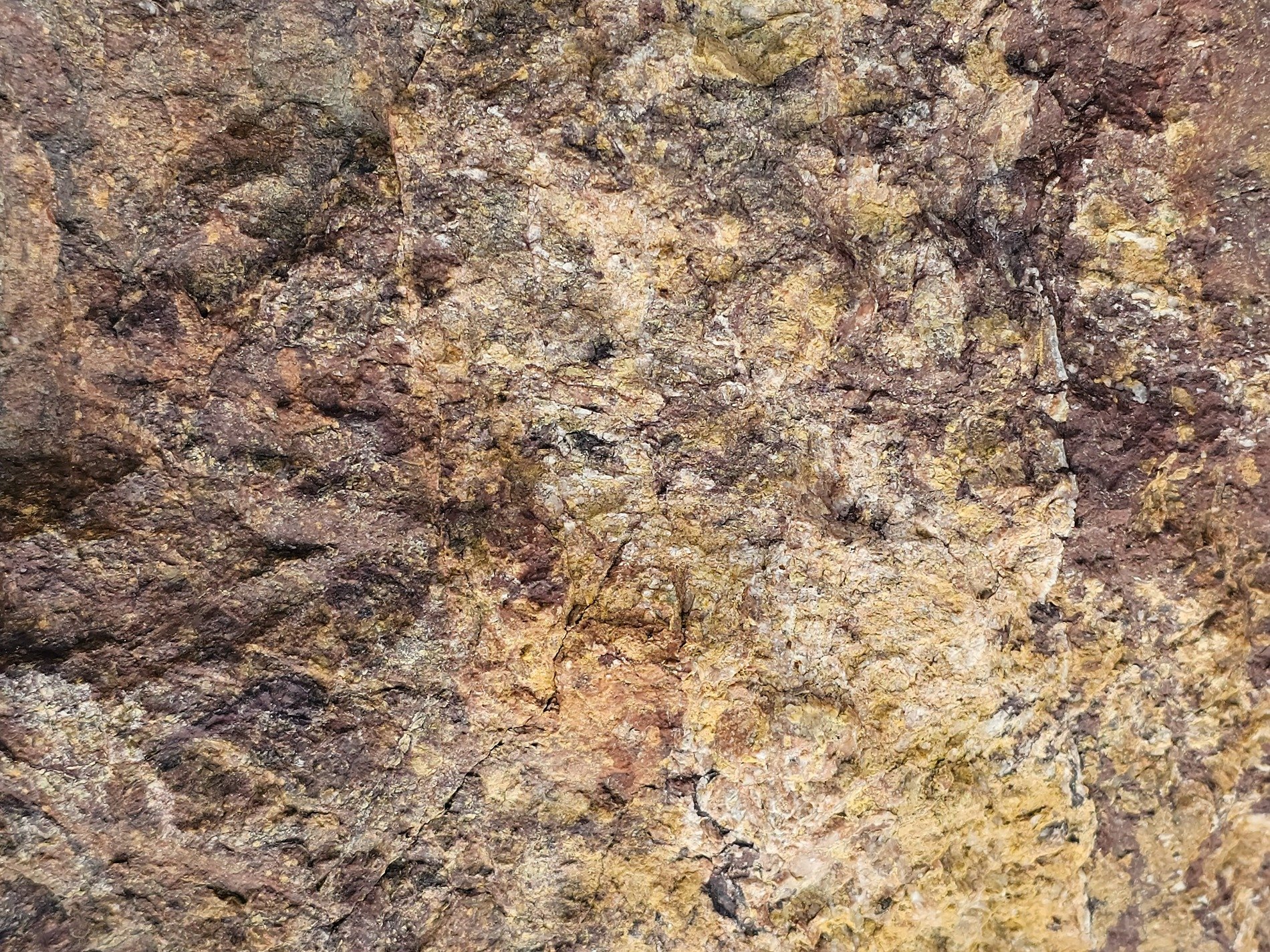 Pink crystalline grains, grey mineral veins trace the stone, grit holds the pattern