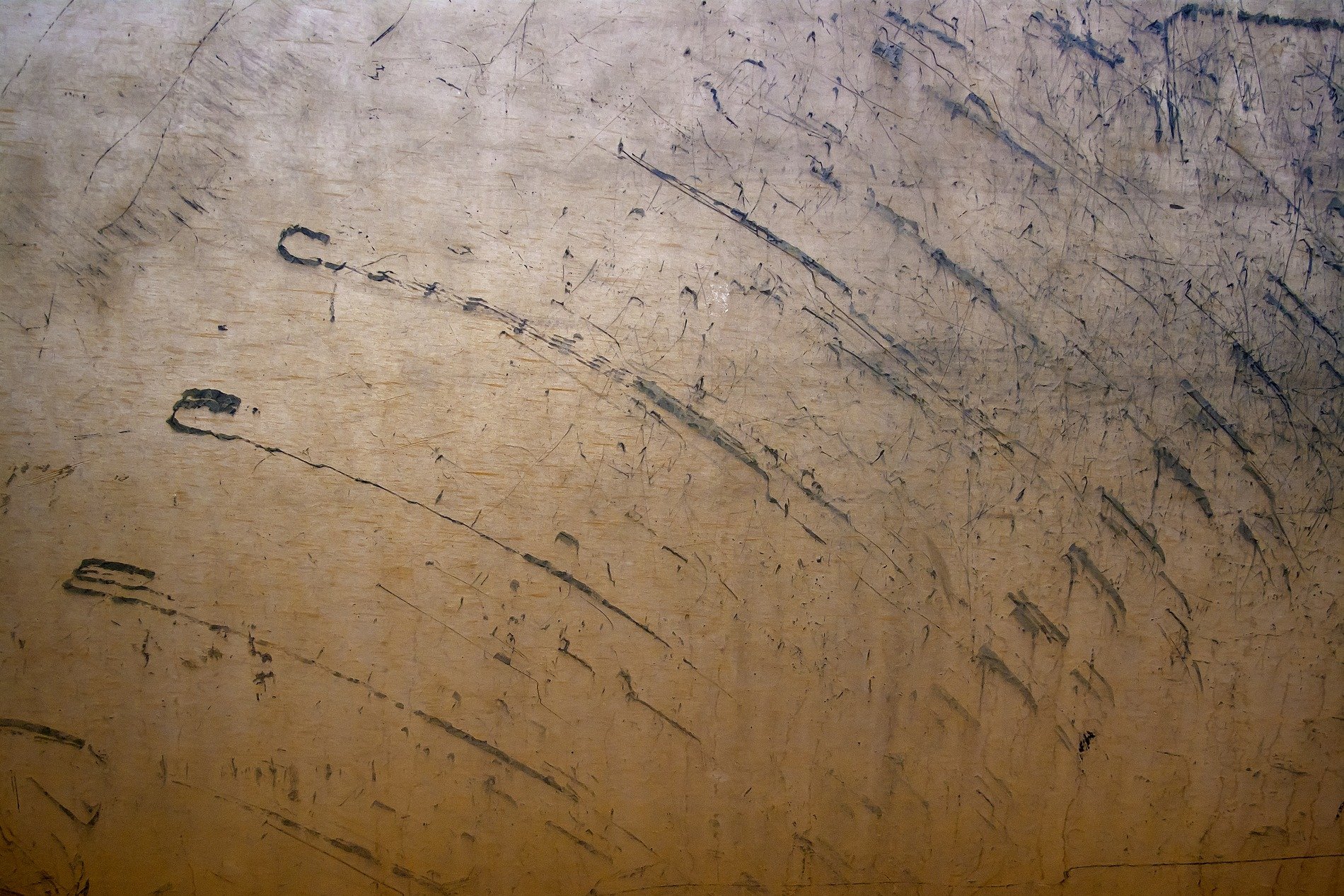 Steel etched by the years, dark marks scar the silent grey, weathered surface waits