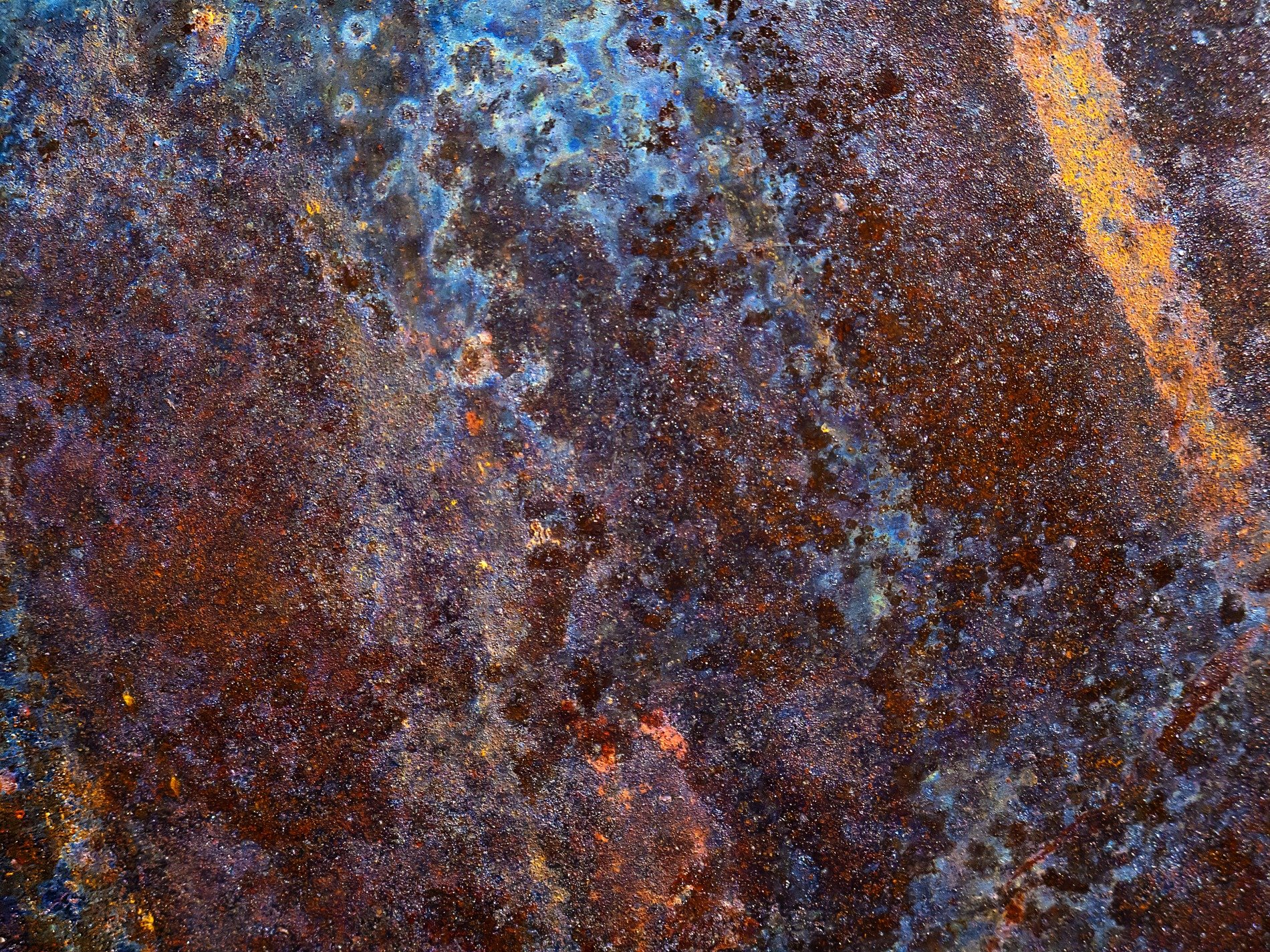 Purple rust holds fast, red minerals bloom on dark, time wears down the plate