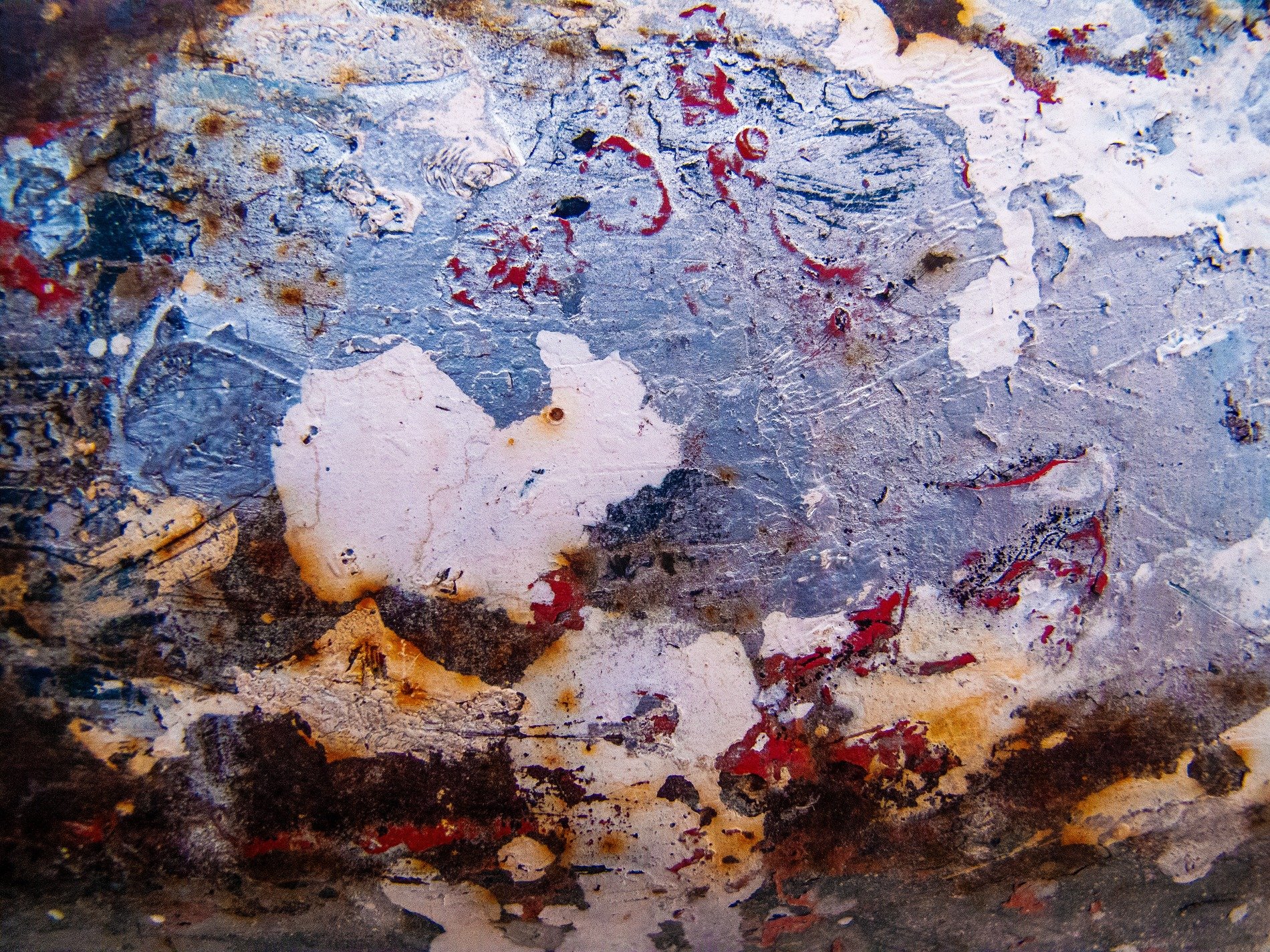 Red roses on the wall, faded floral marks the paper, pattern holds the age