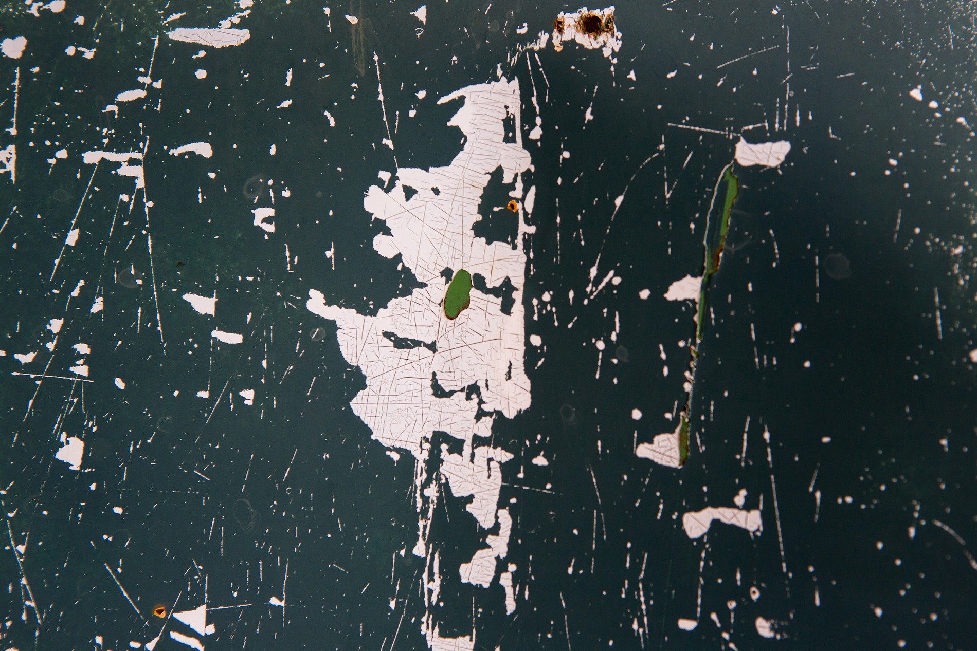 Red skin flakes away, orange oxidation claims the surface, grit marks the decay