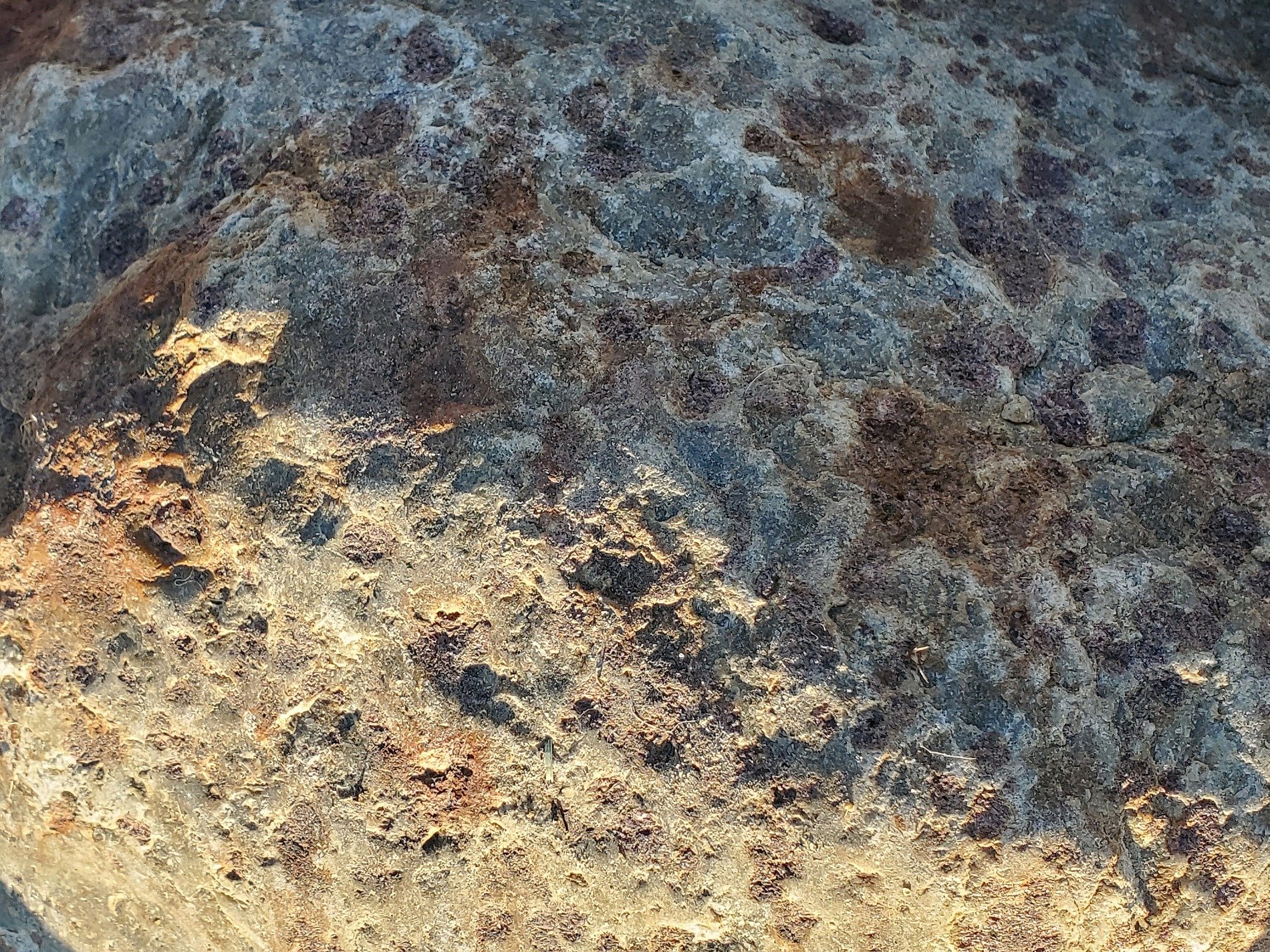 Red spots on the stone, purple minerals emerge, grit holds the pattern