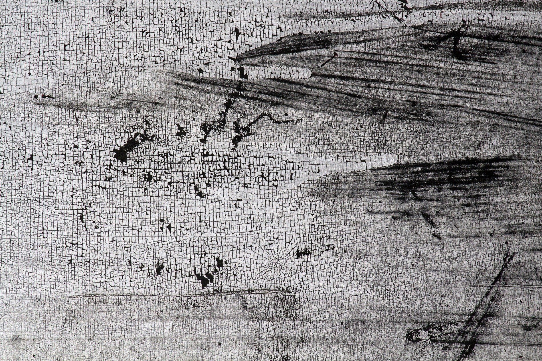 Rough pits scar the grey, jagged lines trace the surface, time wears the finish