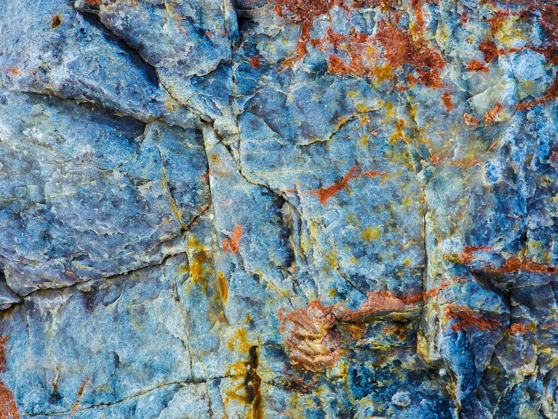 Rough pits scar the grey, jagged marks trace the surface, time wears the finish