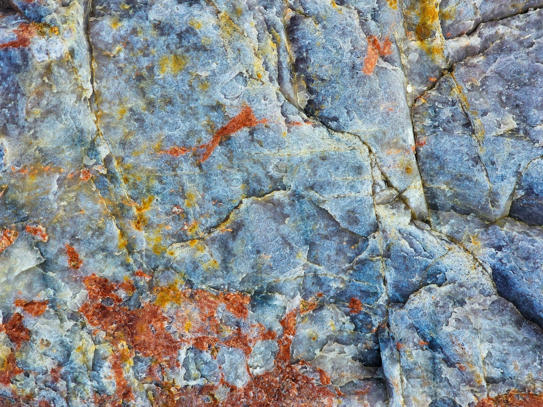 Blue stone starts to crack, orange rust flows through the lines, time reveals its depth