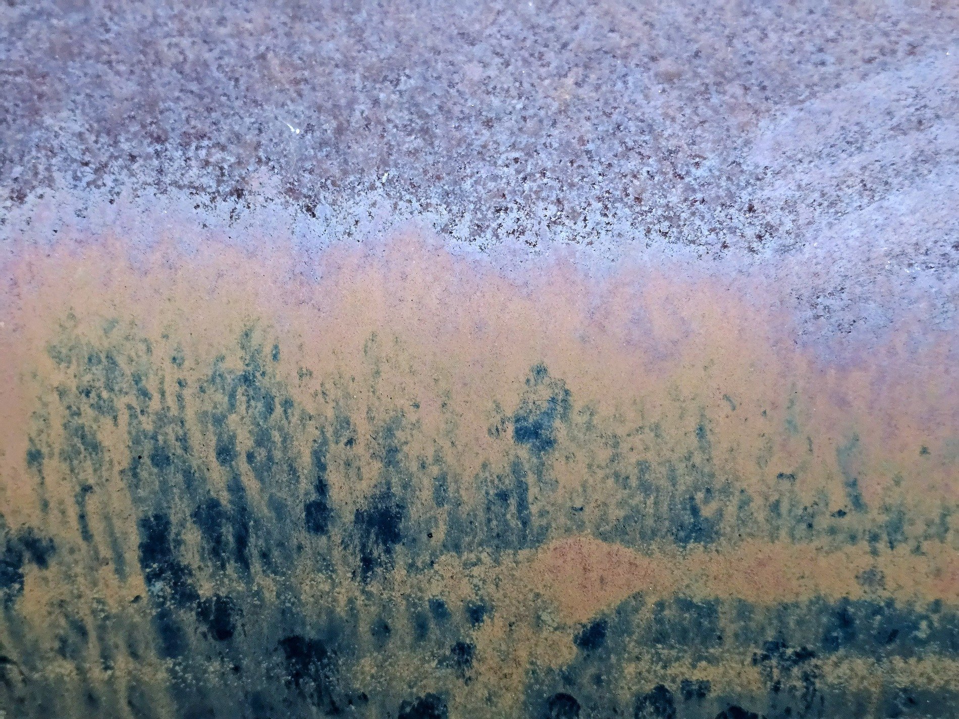 Rust trees on the steel, orange mist meets the blue field, grit holds the shoreline