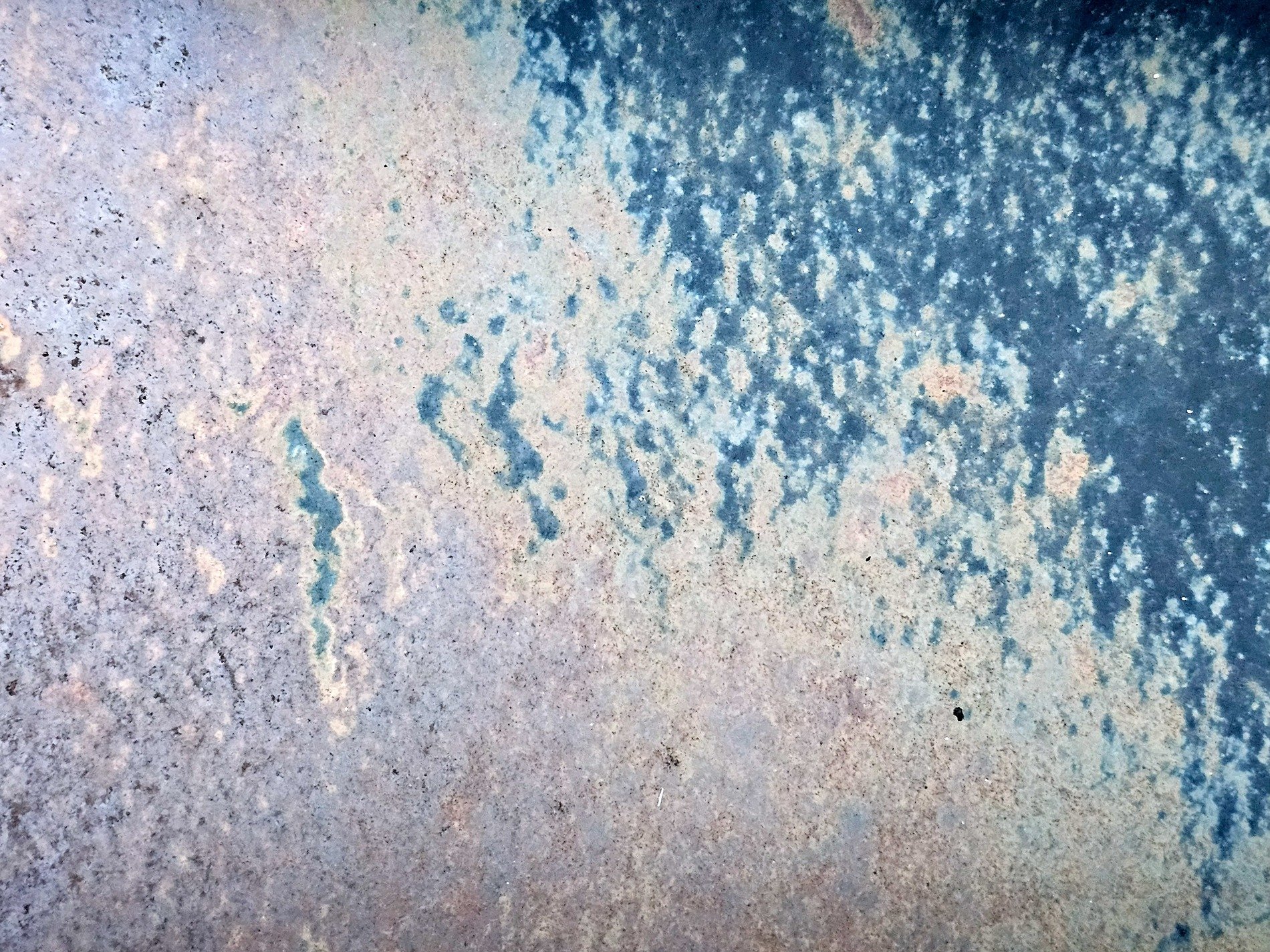 Blue paint wears away, rust blooms on the weathered plate, time fades every mark