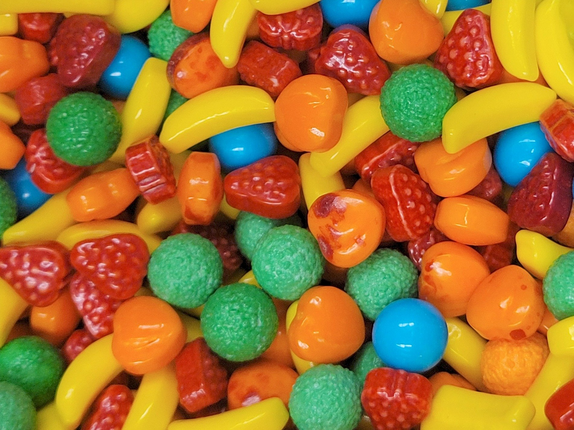 Sweet sugar glimmers, fruity shapes in rainbow hues, crunchy shells of joy