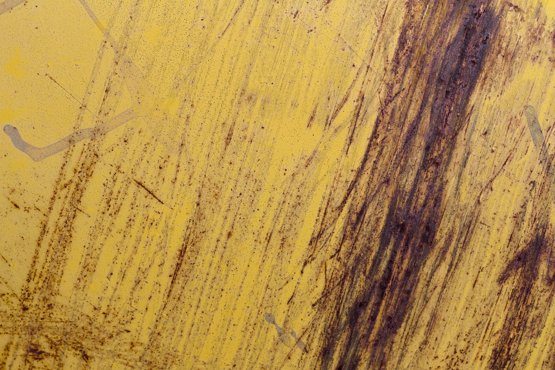 Bright yellow face fades, rust bleeds in long dark streaks, steel shows age in scars