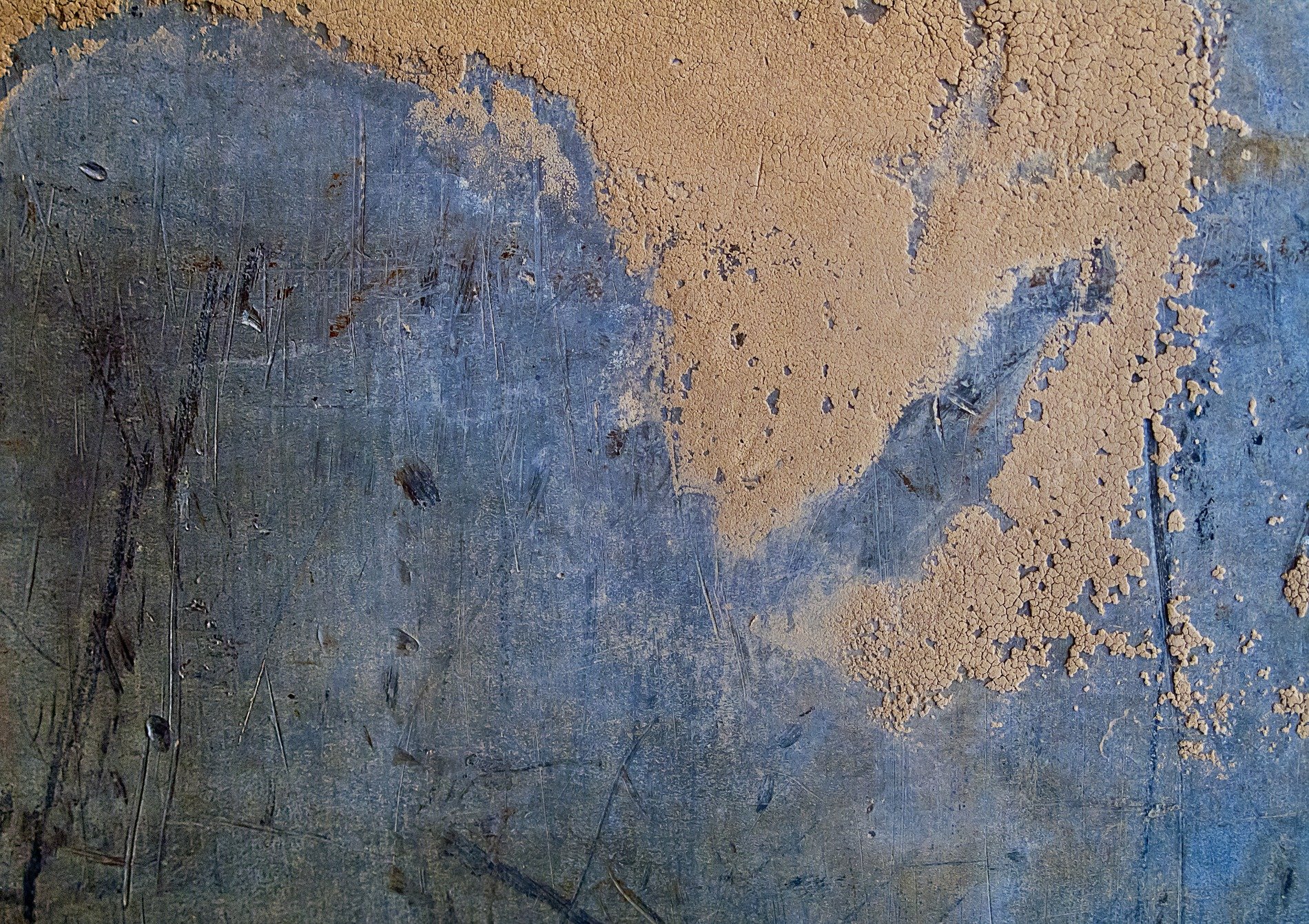 Silver skin has pits, grey scars trace the metal plate, grit holds the surface