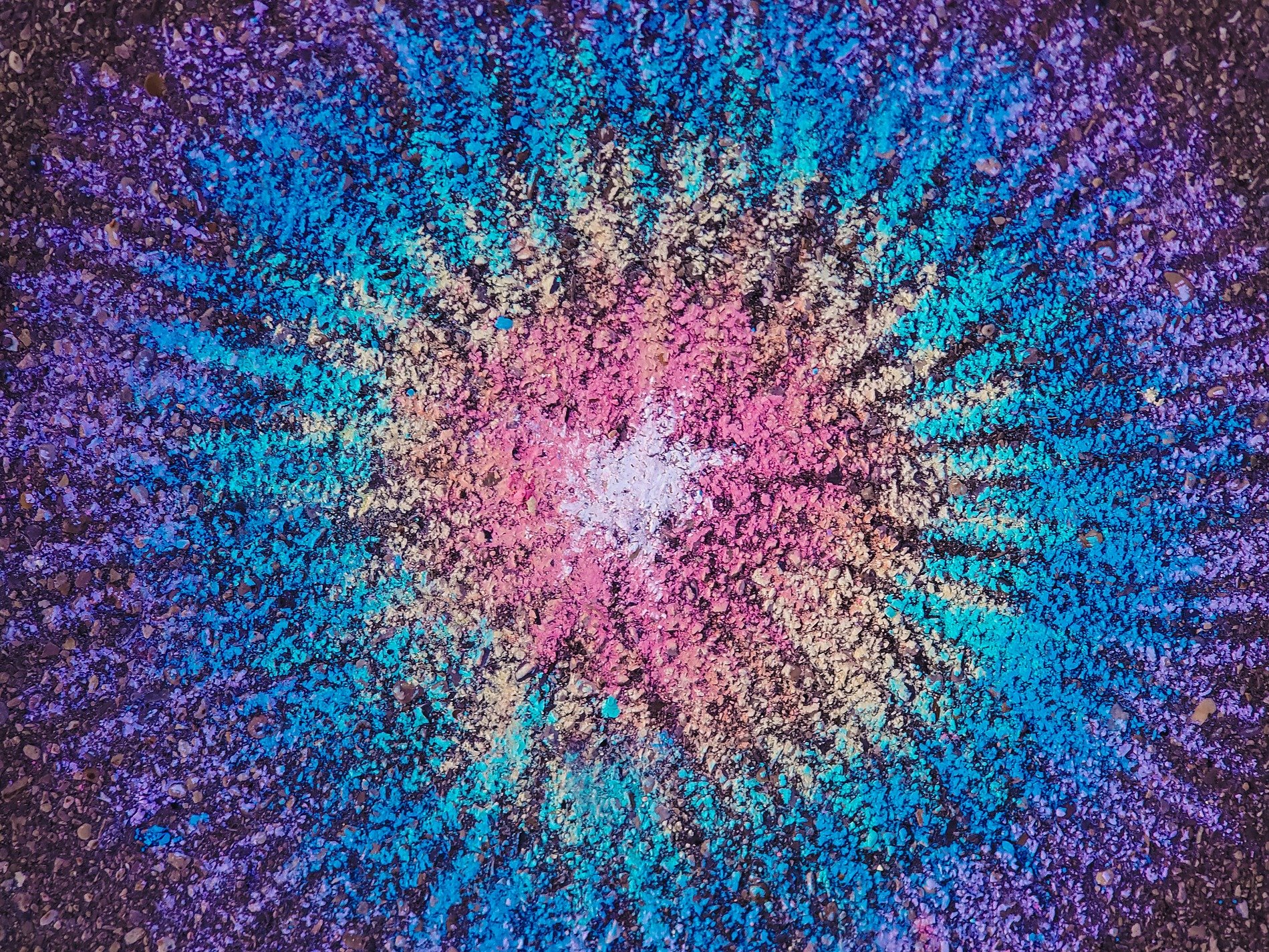 Bright dust paints the ground, starburst of neon pigment, rough stone holds the spark