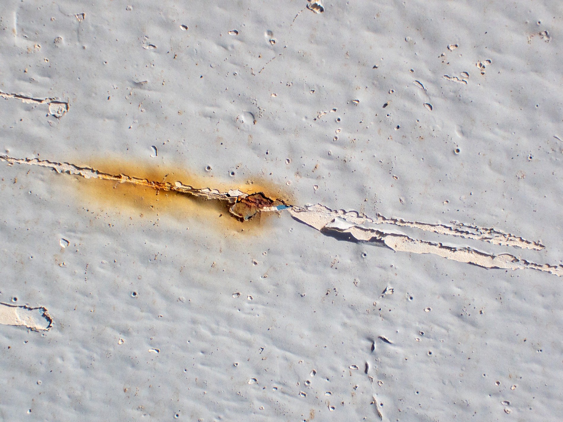 Silver wood holds the grain, grey marks trace the board, time wears the finish