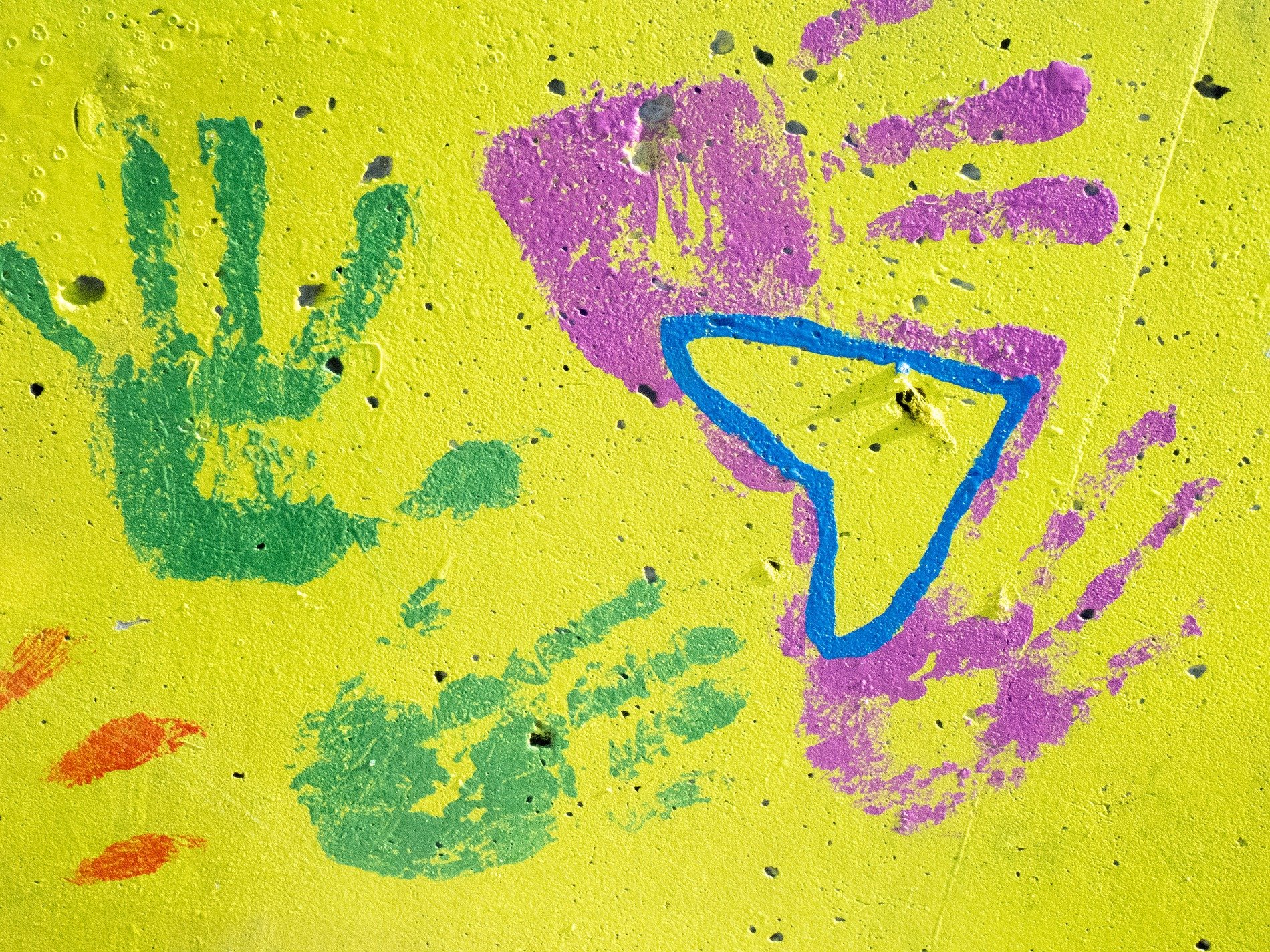 Painted hands remain, yellow stone holds every palm, color meets the rough