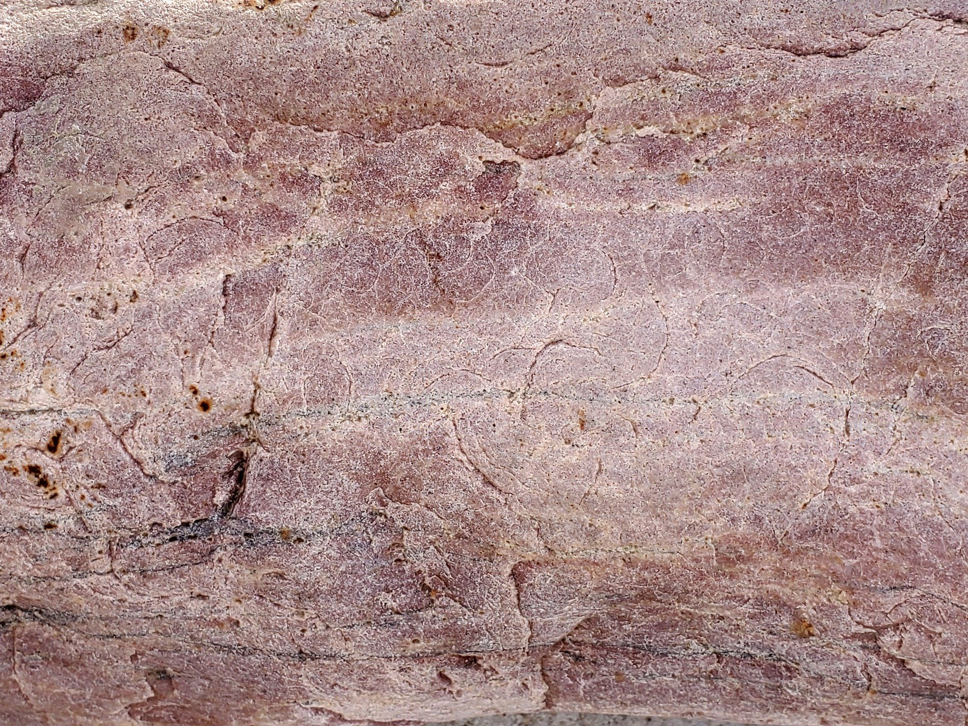 Tan grains flow in lines, horizontal veins hold light, time carves the pattern