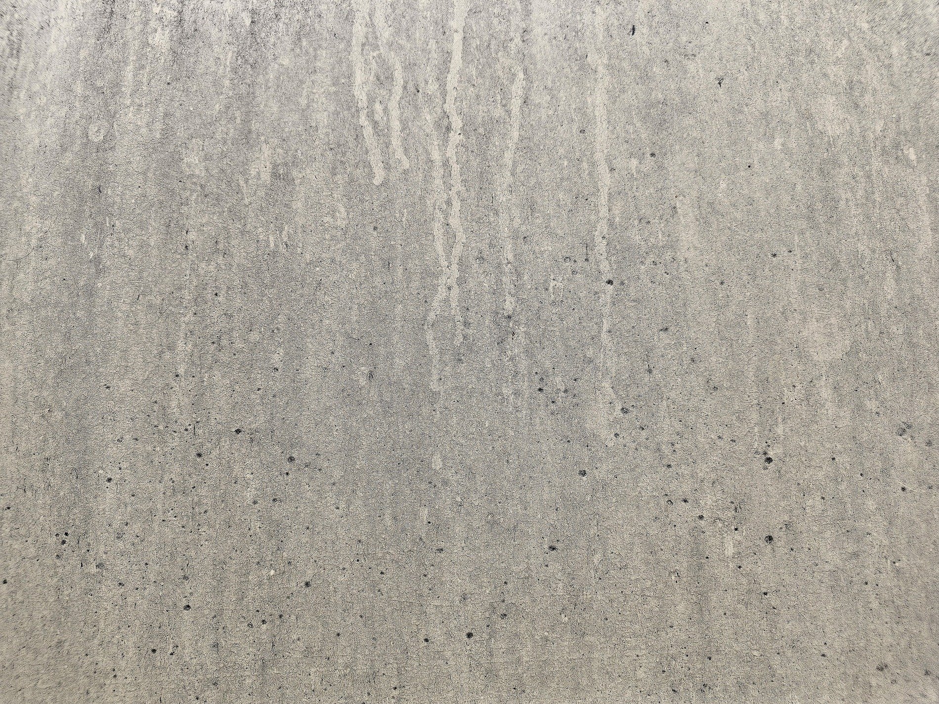 Tan pits on the wall, black streaks mark fading paint, grit meets the rough board