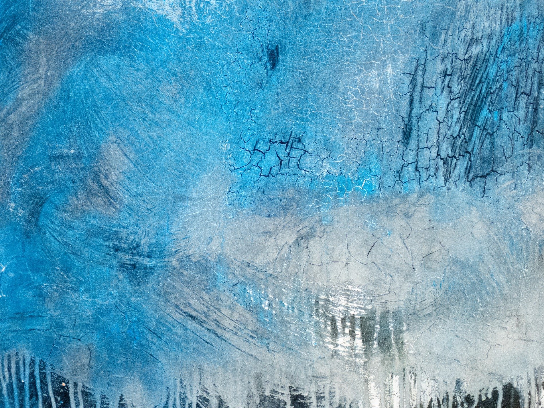 Tape marks on the pane, jagged adhesive meets the grey light, grit holds the residue