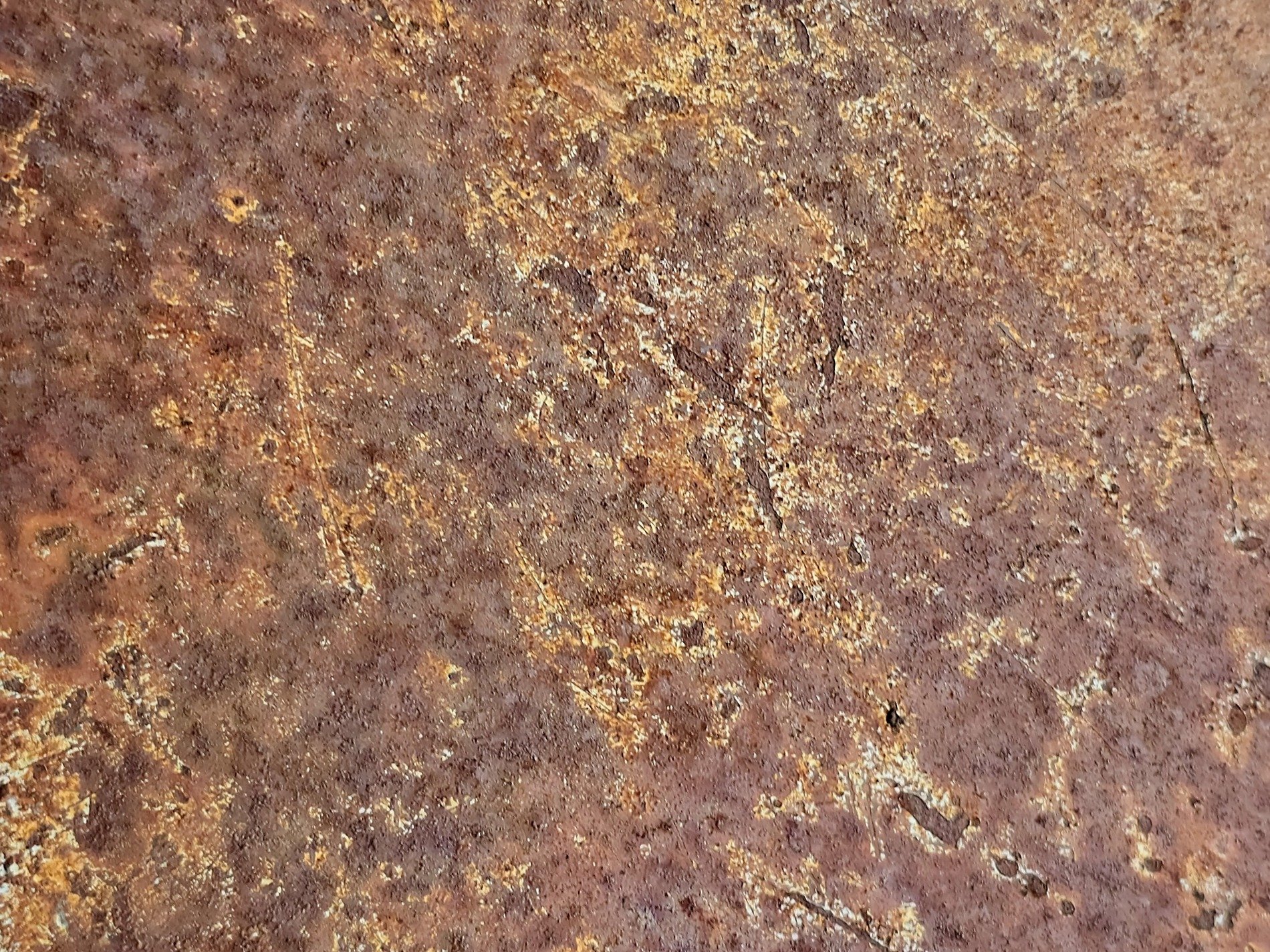 Teal paint holds the edge, orange rust blooms in the center, steel wears thin