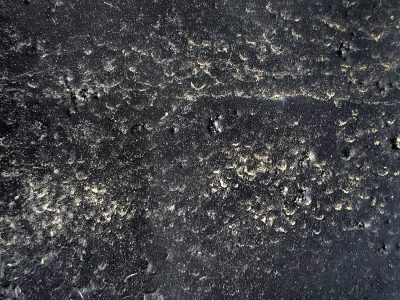 Black pits in the gloss, golden grit fills every scar, time claims the finish