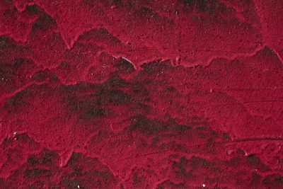 Blue automotive paint meets deep rust, orange oxidation claims the steel fender, grit holds the decay