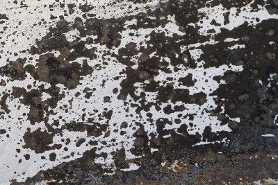 Blue fields meet the rust, orange mist on the car steel, grit marks the shoreline